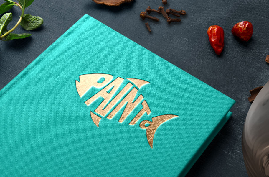 Logo-Mockup von Paint a Fish auf einem türkisfarbenen Buchcover. Das neue Fisch-Logo ist in goldener Prägung dargestellt und wirkt modern sowie hochwertig.