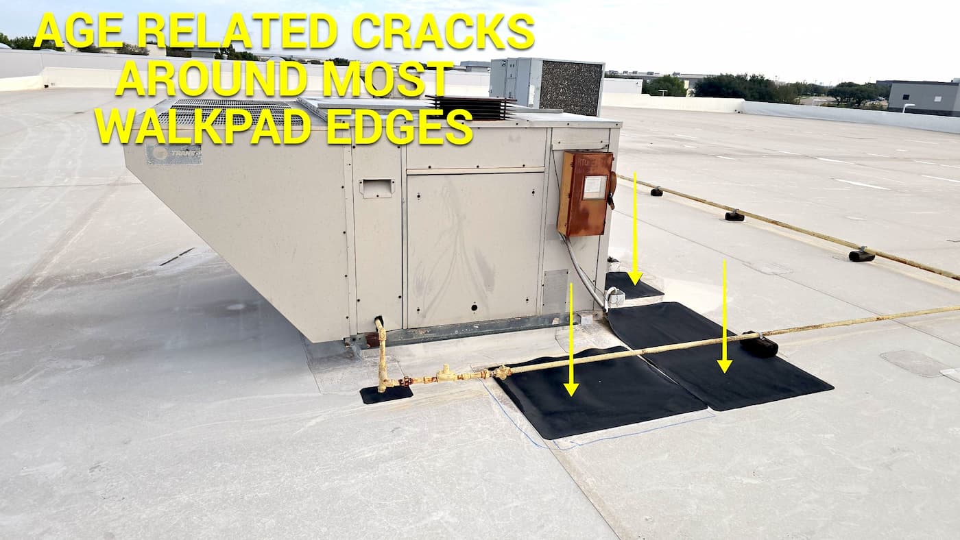 Commercial roof - Age related cracks around walkpad edges.