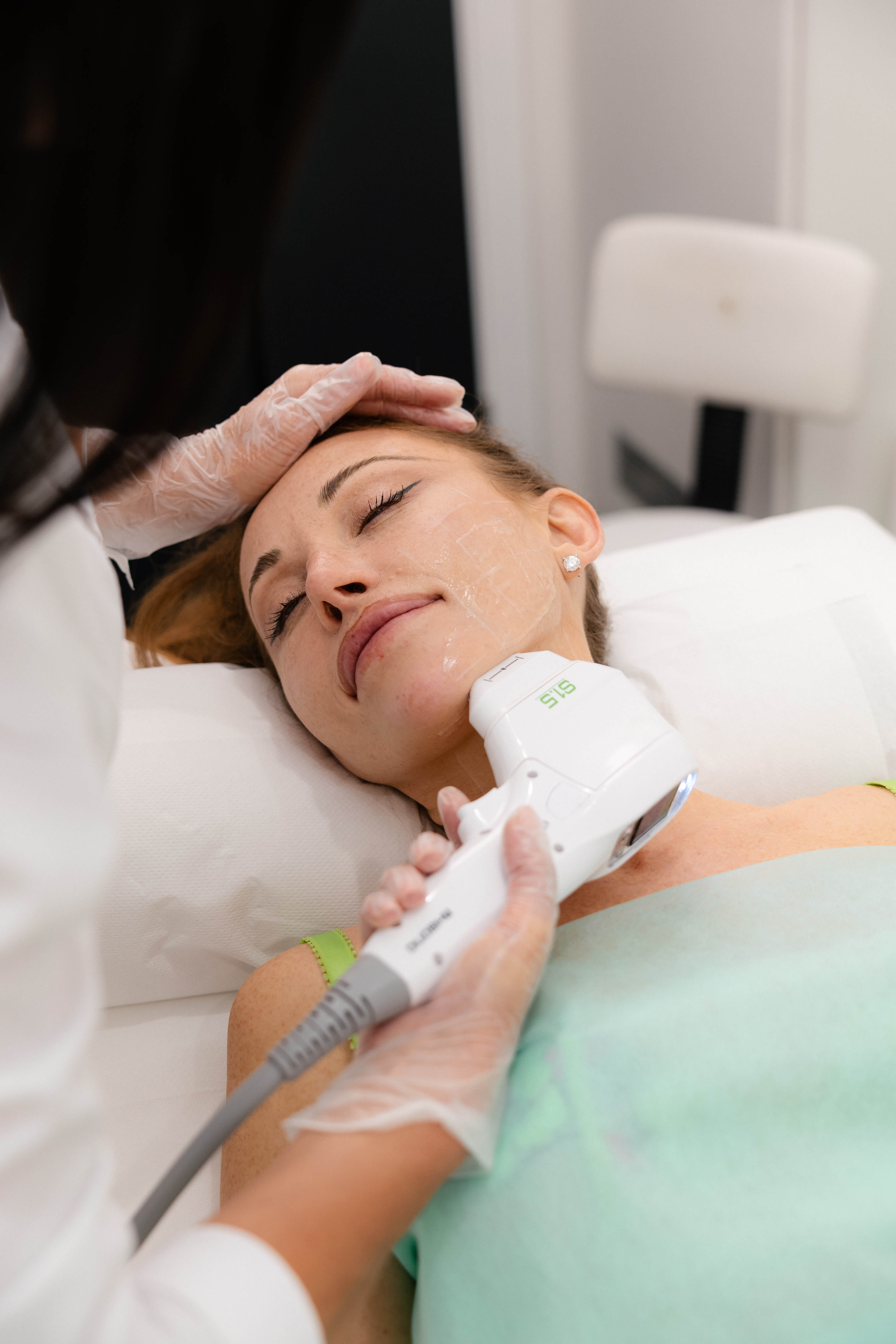 Client receiving a non-invasive facial treatment with professional aesthetic equipment.