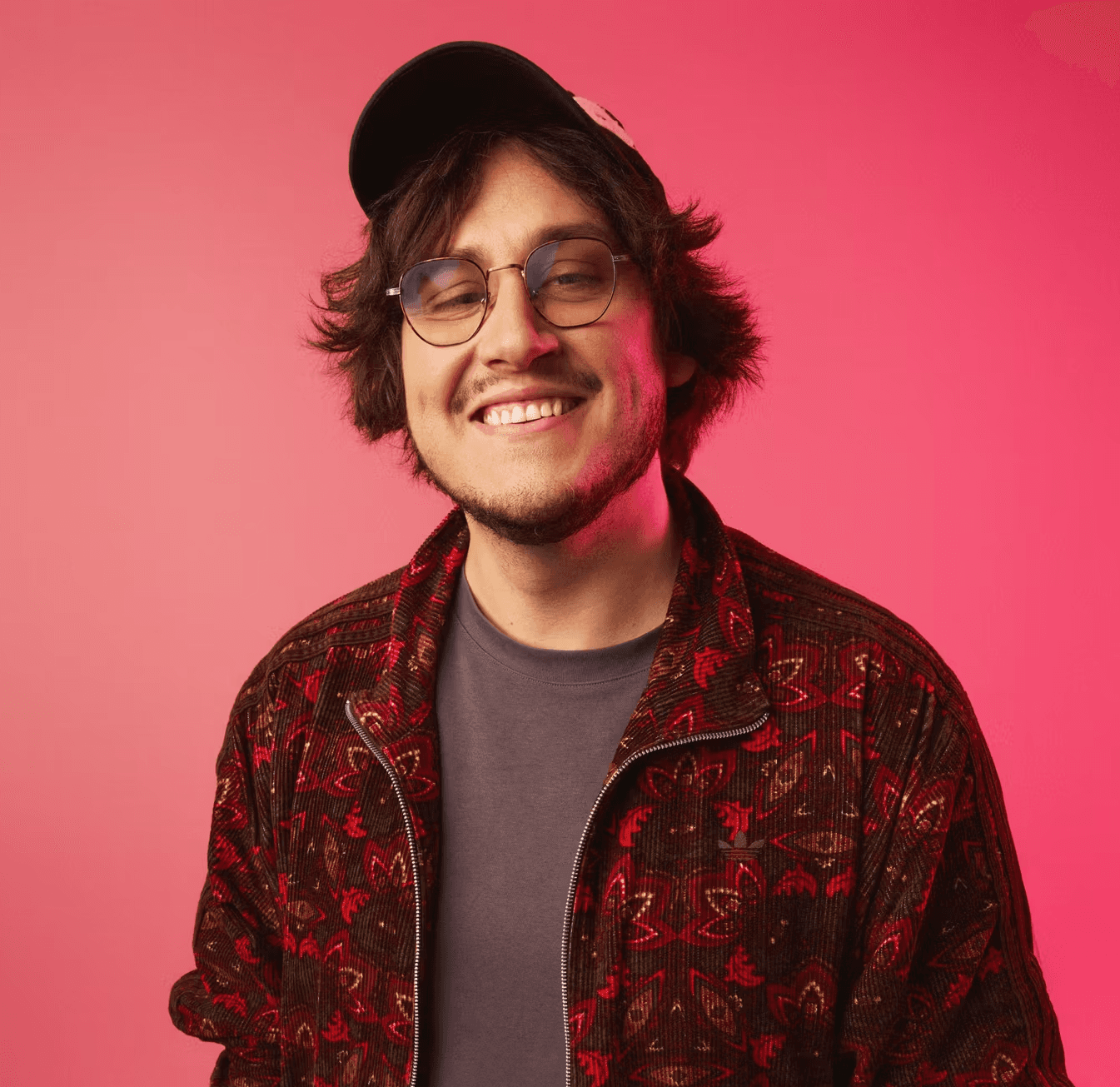 Vincent sourit devant un fond rose