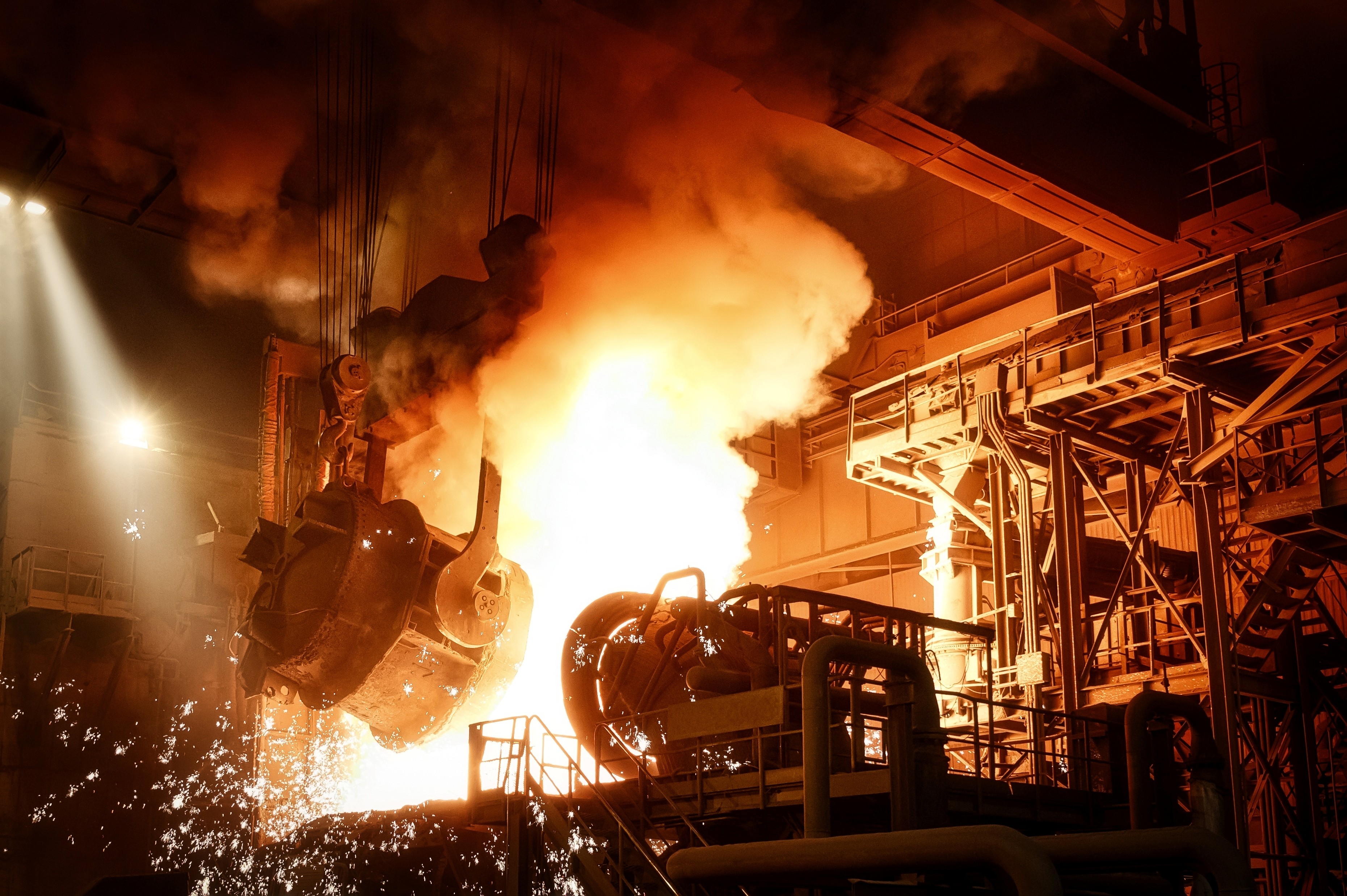 Molten steel being poured in a foundry with heavy industrial machinery