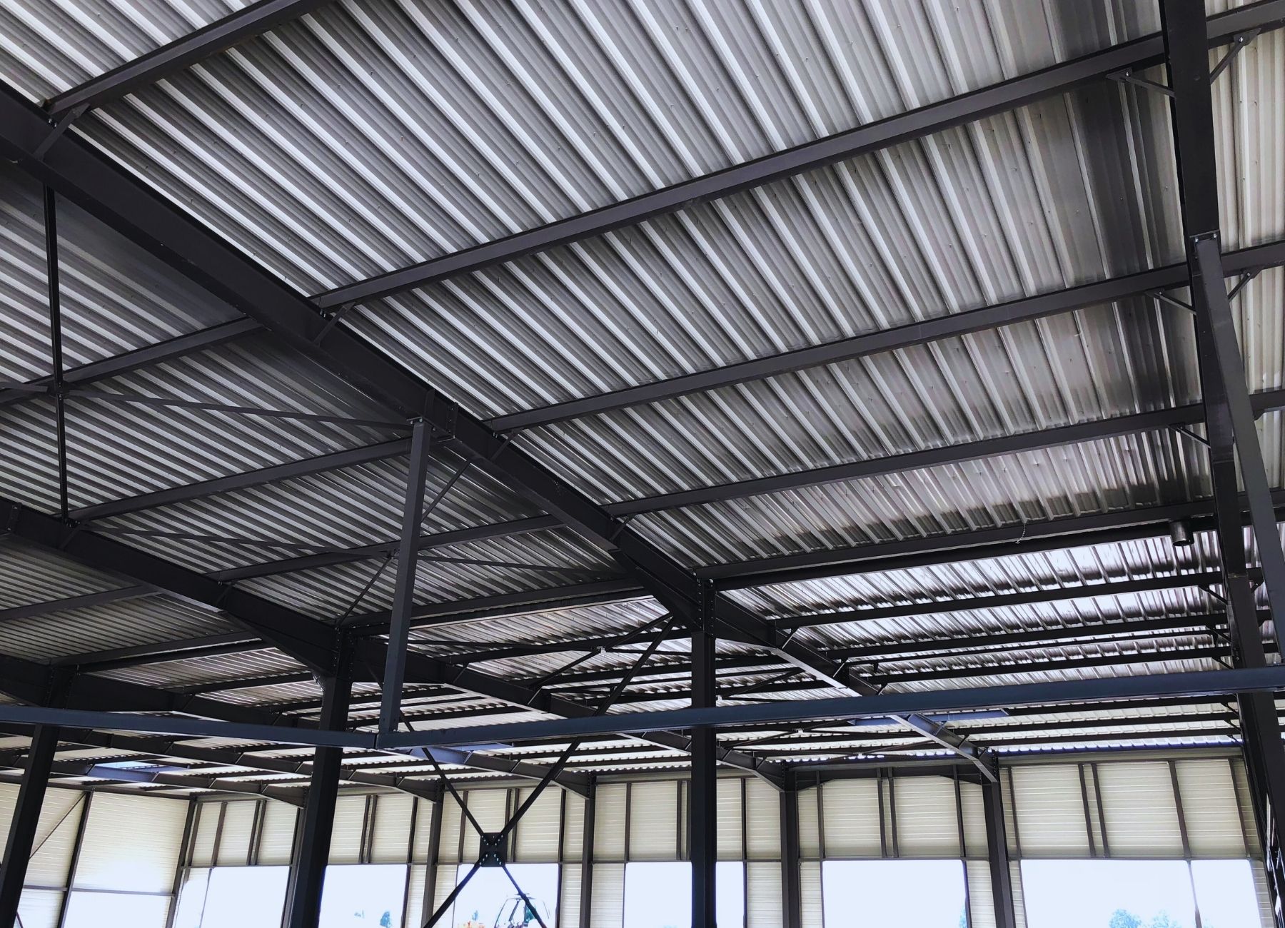 Structure de toiture métallique avec poutres treillis et éléments porteurs en acier.