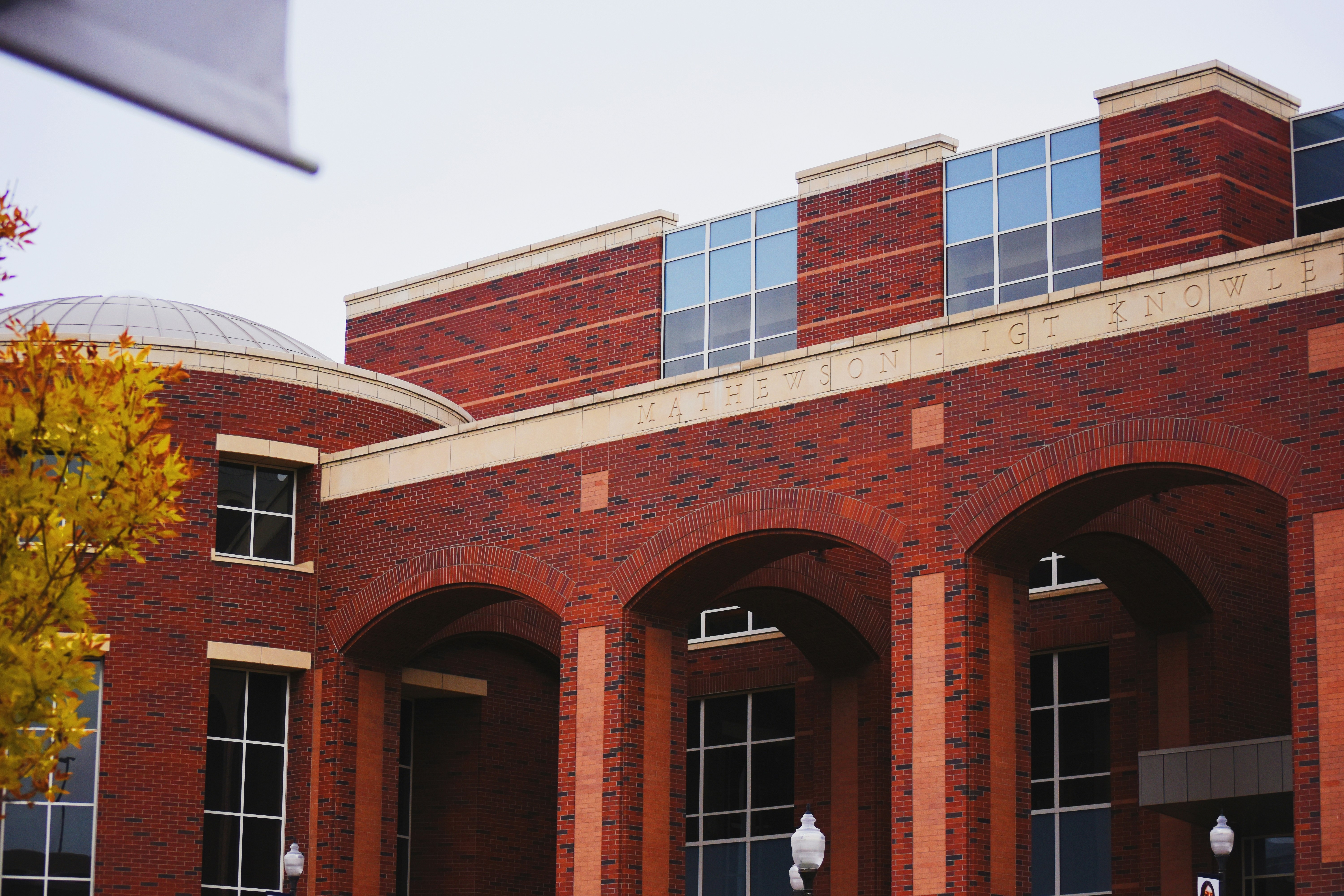 a brick building with a few people walking out front