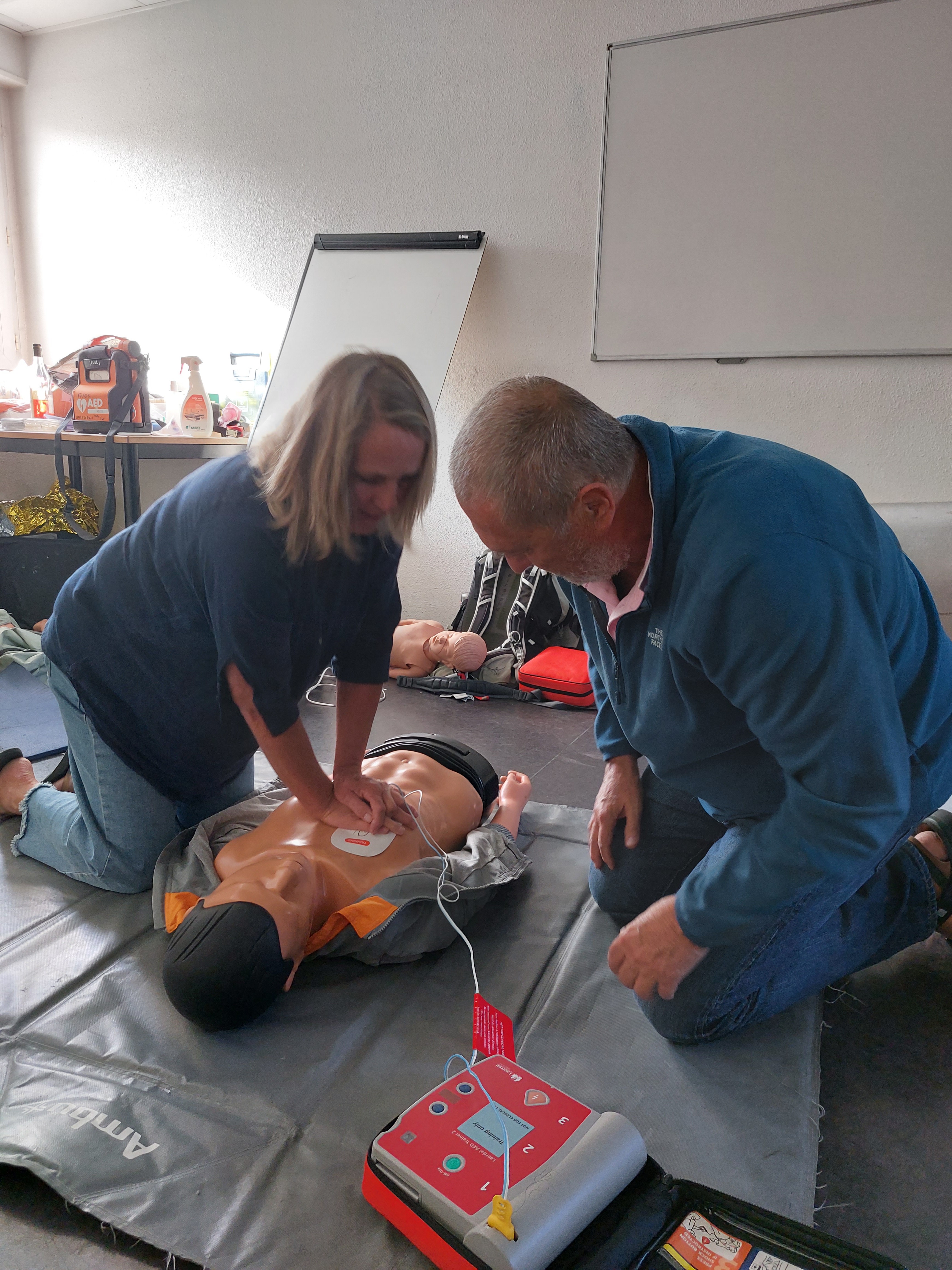 Formation GQS avec mannequin et défibrillateur dans une salle de classe.