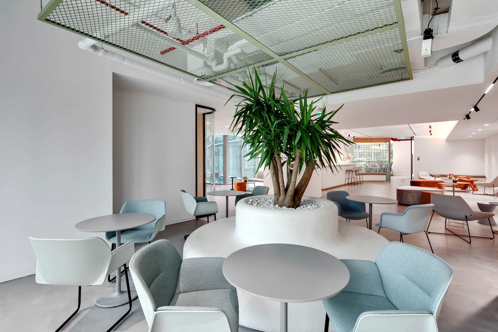 A conference room featuring blue chairs and a circular light, located in The Binary by OMNIYAT.