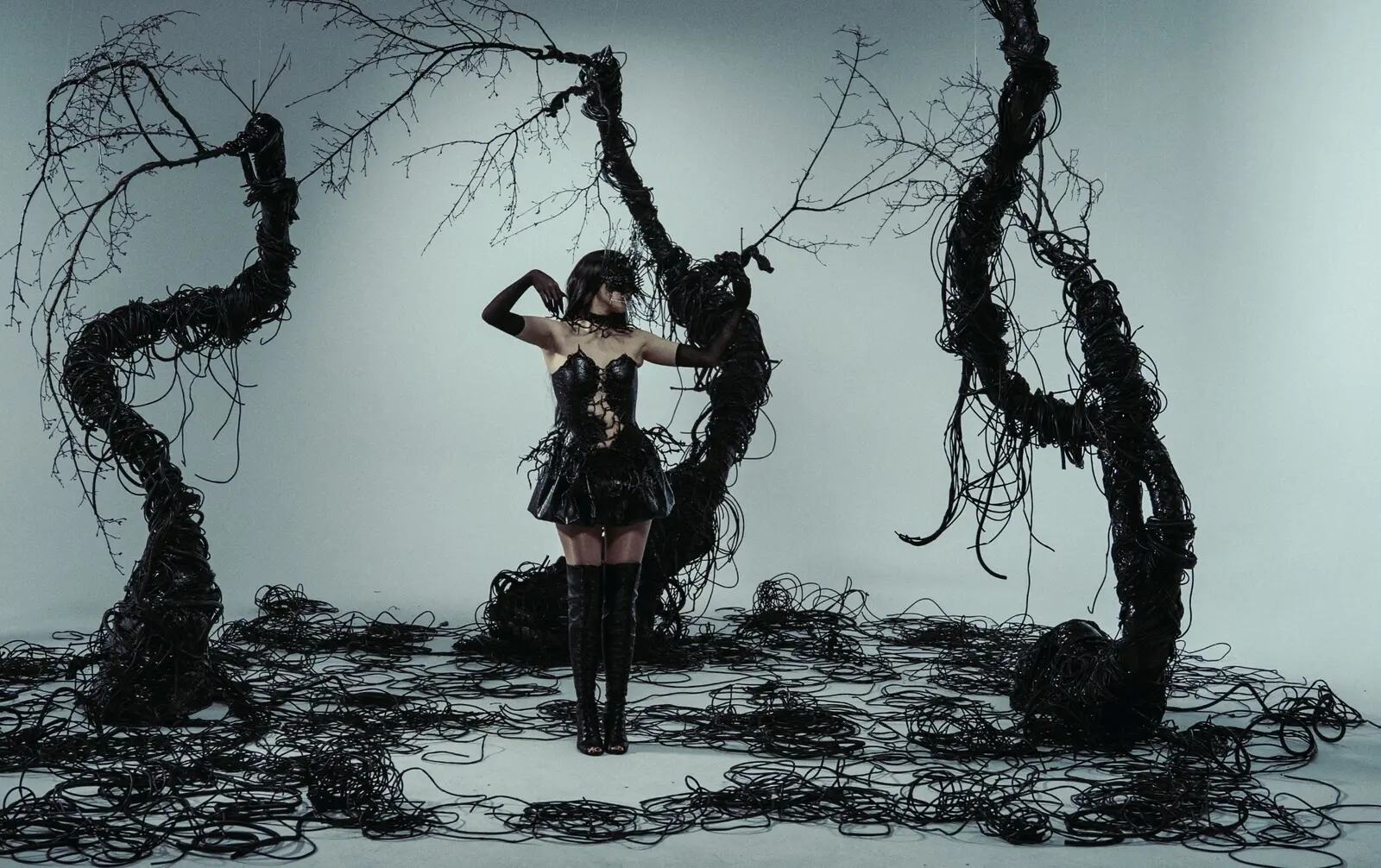 Finished music video frame with an artist surrounded by sculptural black set design