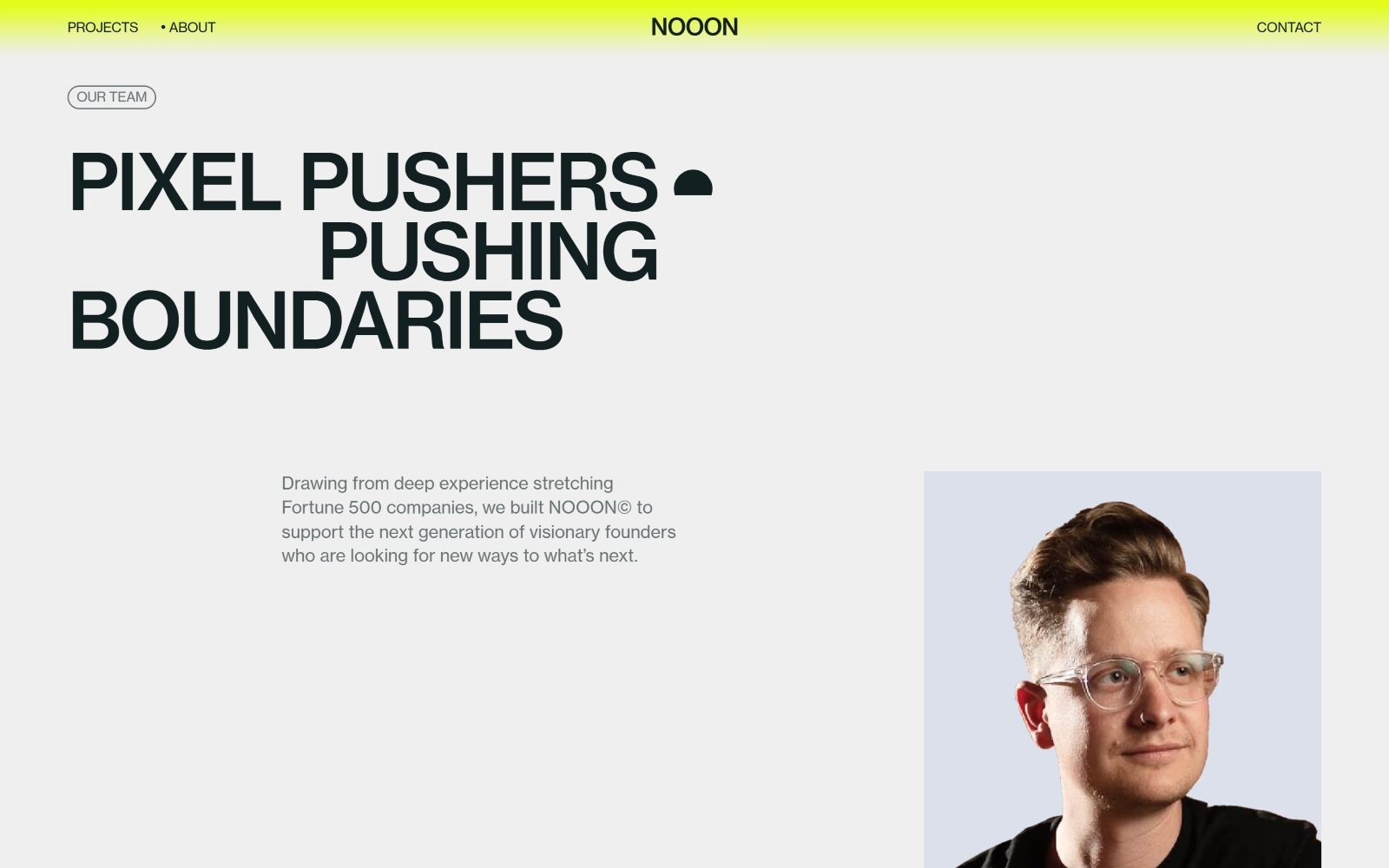 Yellow header with "NOOON" in black. Large text: "PIXEL PUSHERS - PUSHING BOUNDARIES." Portrait of a person with glasses.