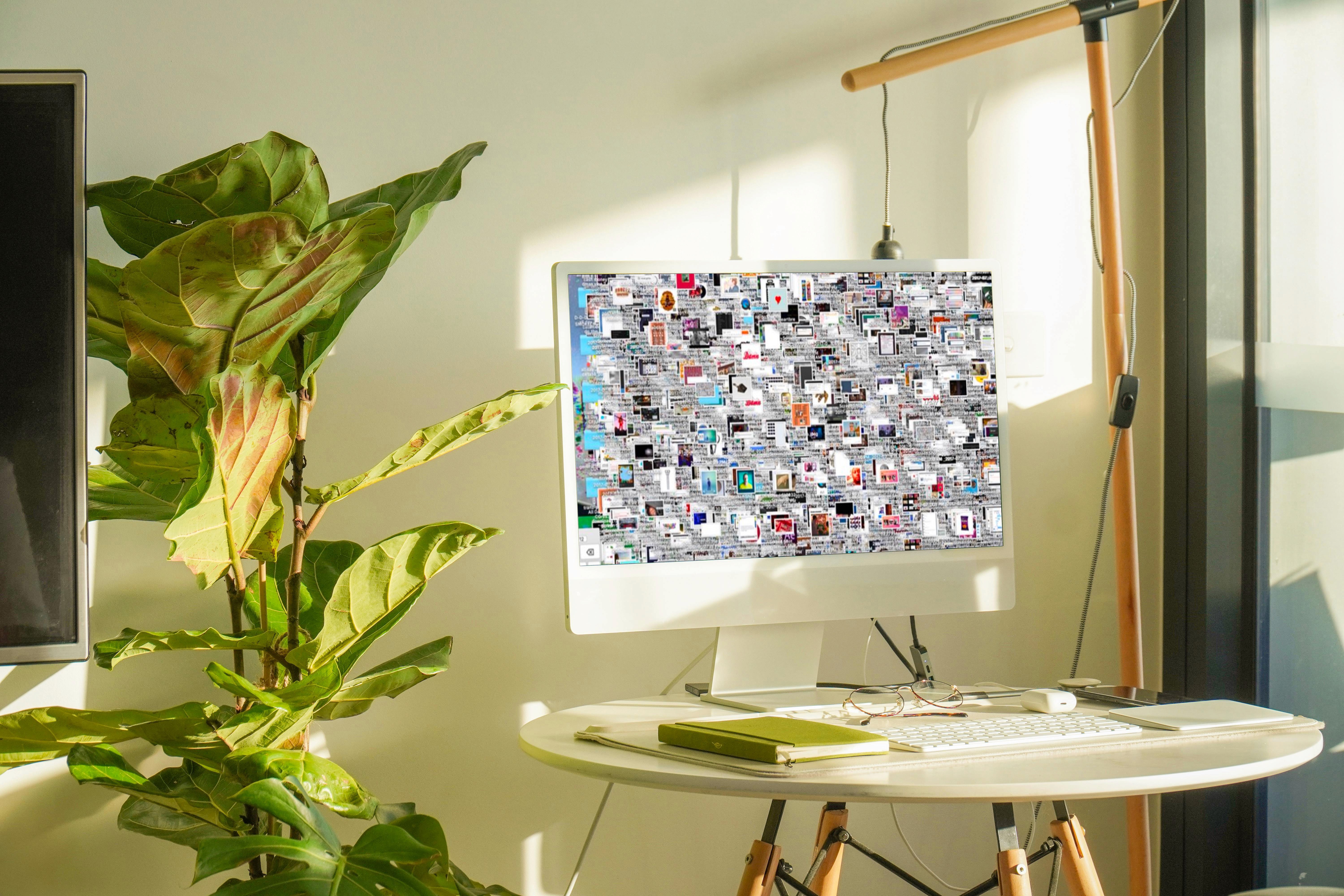 Desk with computer displaying a densely organized photo collection.