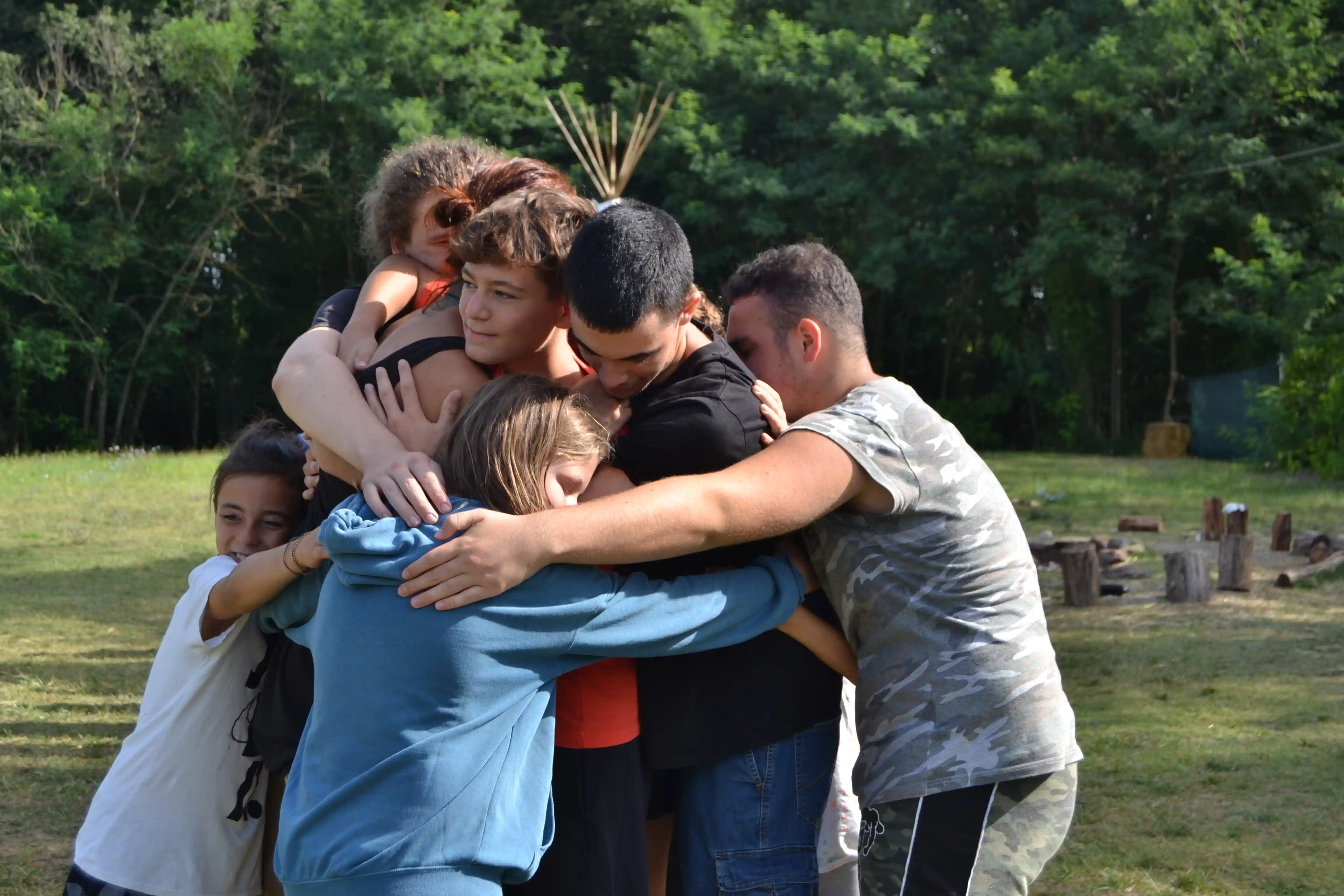 Team di educatori ambientali uniti in cerchio, specializzati in outdoor education, campi estivi per ragazzi, bushcraft e team building outdoor
