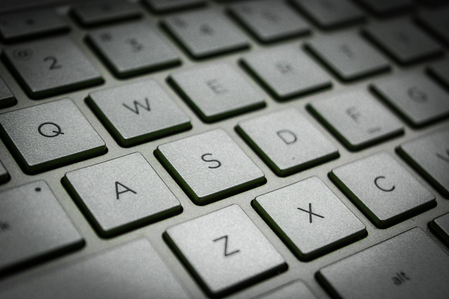 Close-up of a student's hands typing a username and password on a laptop keyboard to access a portal.