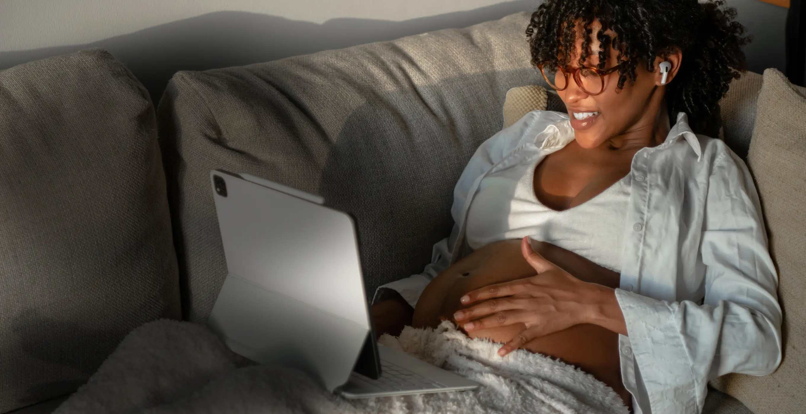 A woman named Jenny O with black hair smiles while sitting on a wooden surface, with shelves in the background.