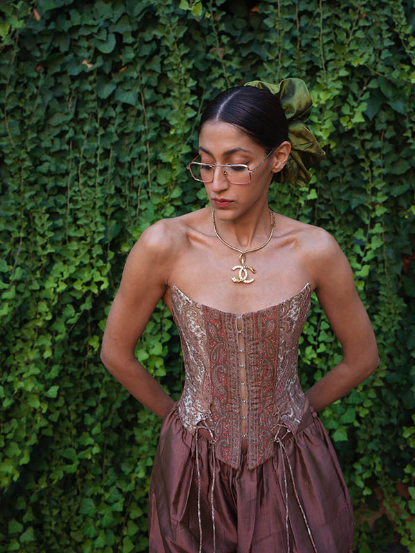 Raina is our one-of-a-kind four-panel corset, handcrafted in-house using a vintage silk saree. The structured silhouette features V-cut detailing at the front, along with lace-up panels on both the front and back,