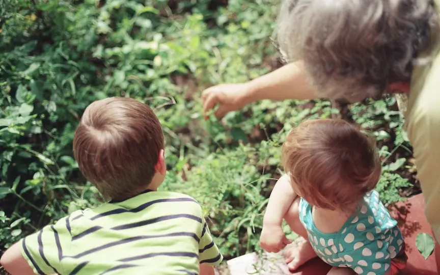 A photo of a grandmother with her two infant grandchildren