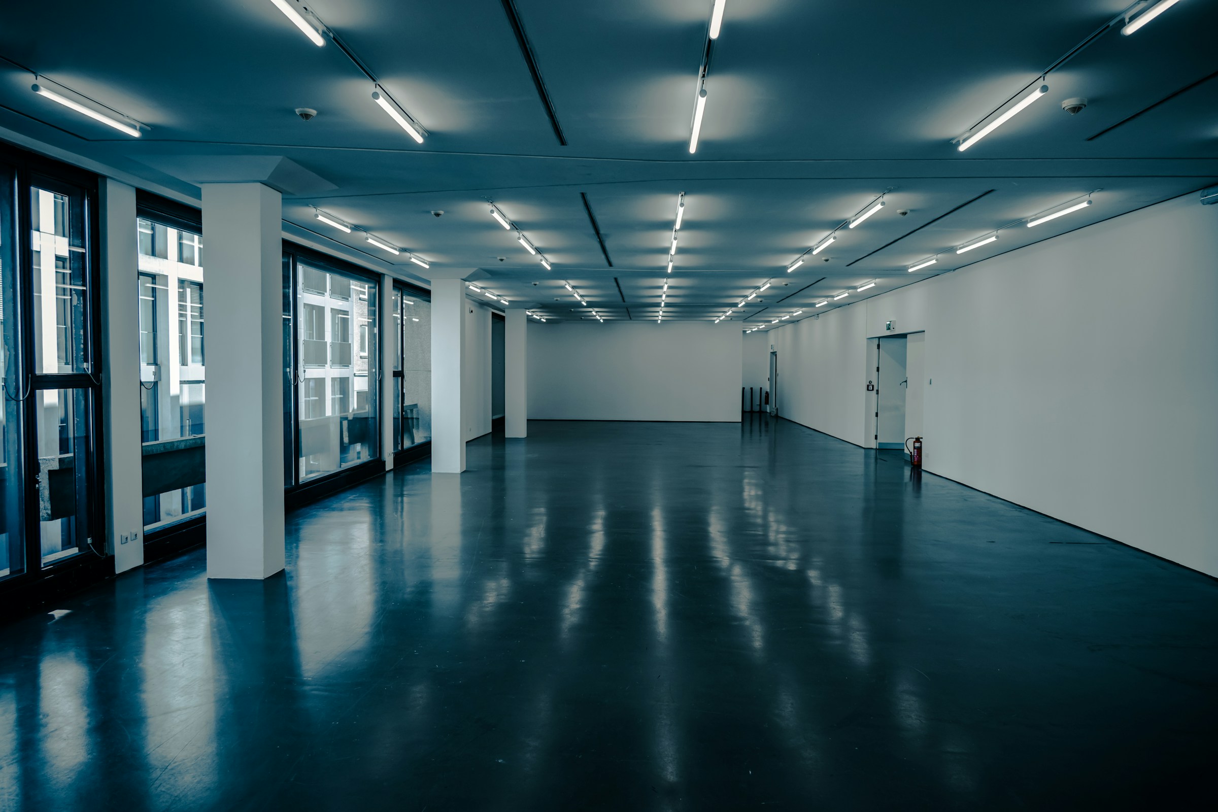 Empty modern exhibition hall with reflective floor and lights