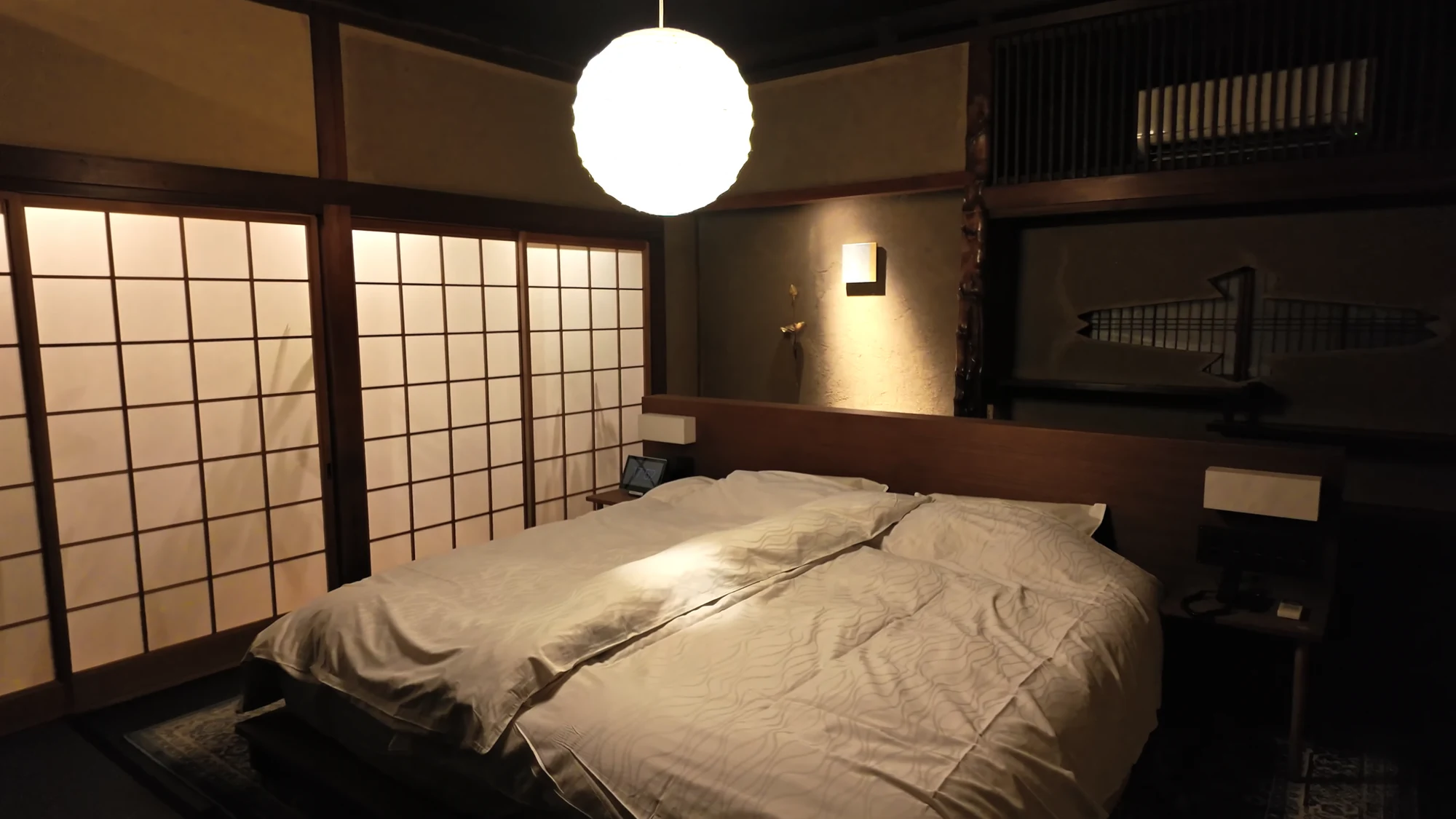 A contemporary Kinosaki guest room with a western bed and timber joinery.