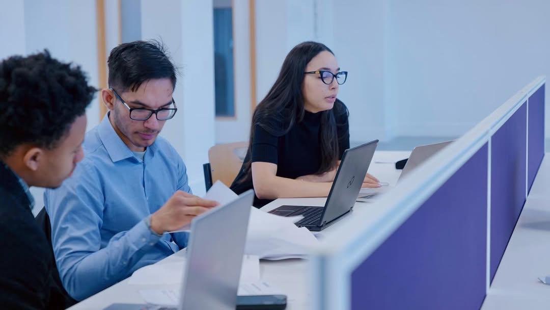 Learners collaborating at a workplace table