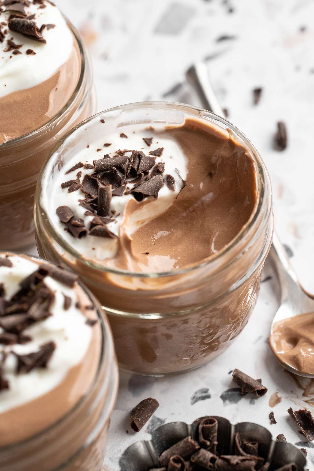 Partially eaten chocolate mousse in a small glass jar.
