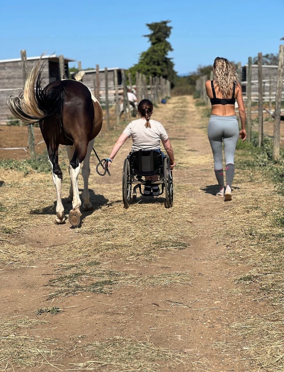 Séance d'équithérapie et d'inclusivité avec un cheval et une personne en fauteuil roulant au Ranch Pegase.