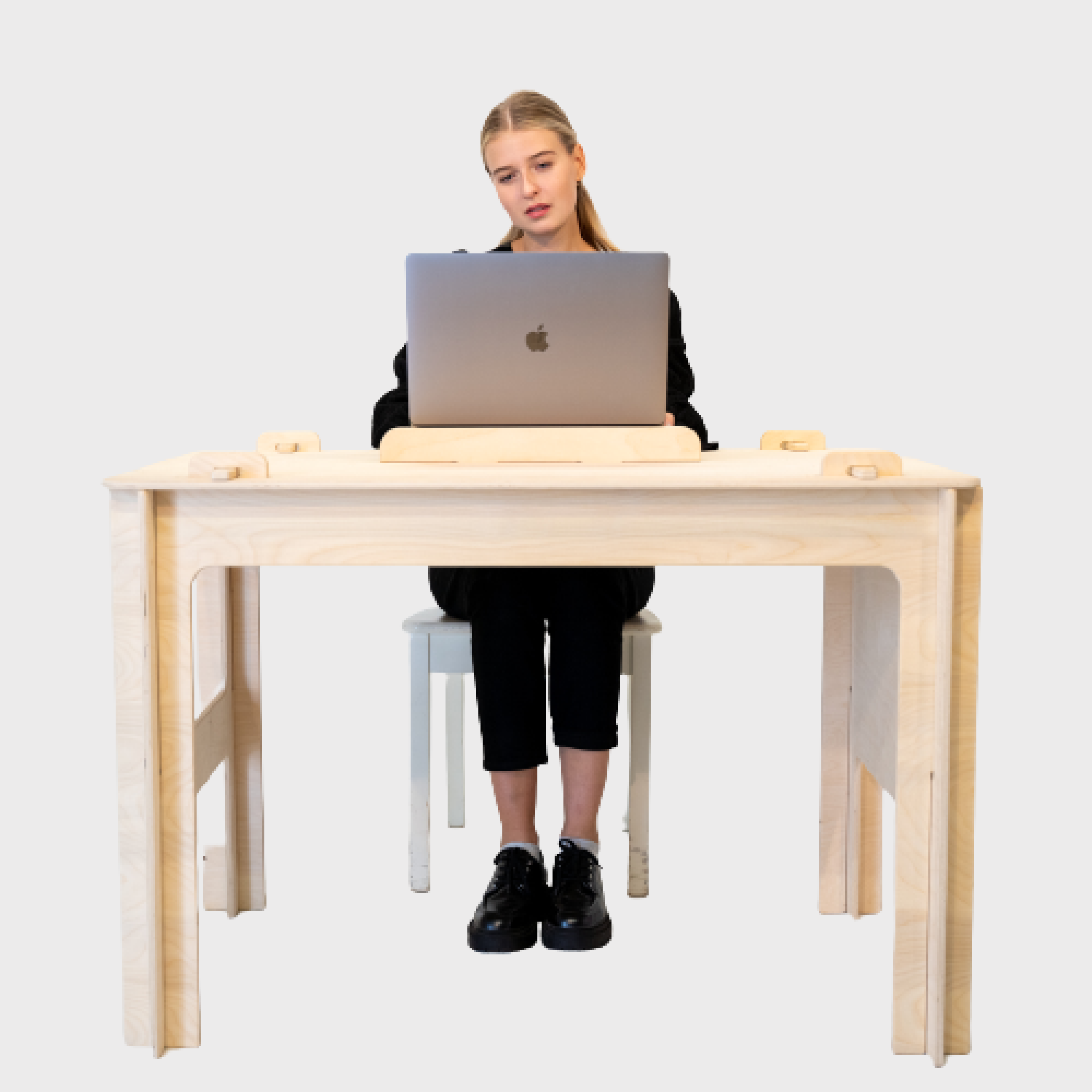 A woman using a silver Macbook Pro on the 100 Tree Furniture quick assembly desk.