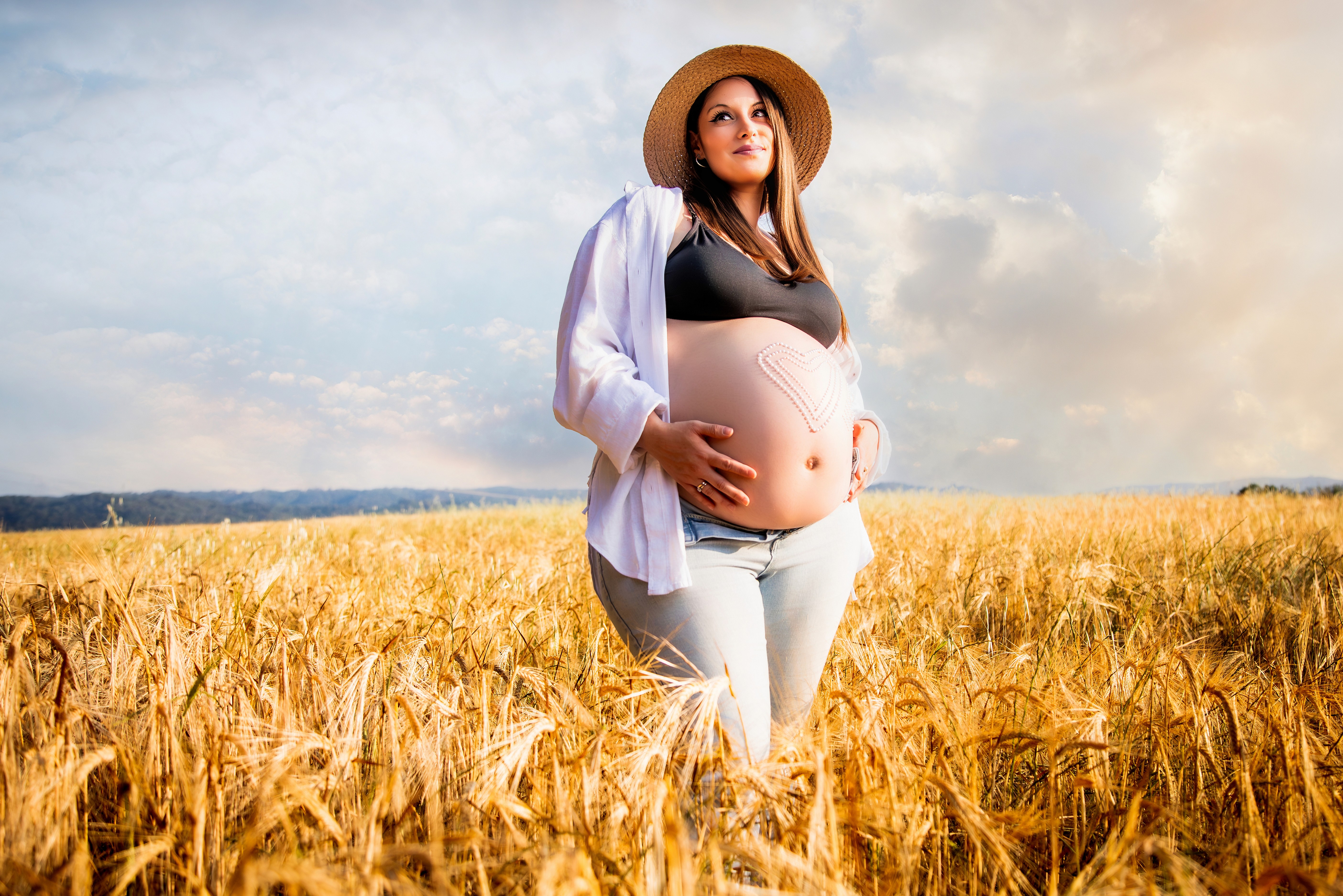 Chica premamá en un campo de trigo