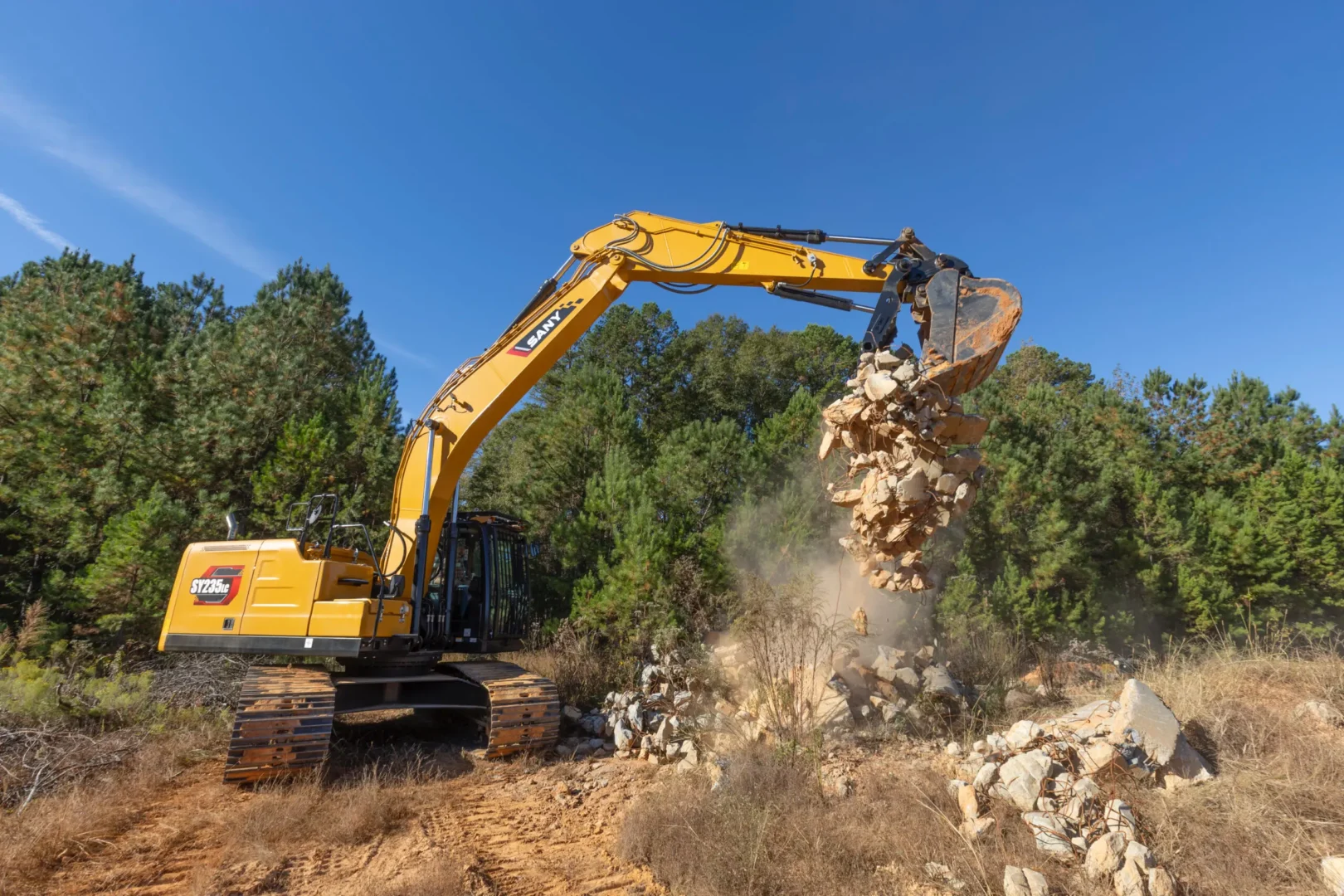 Komatsu excavator moving soil on a grading and earthwork job site under clear skies.