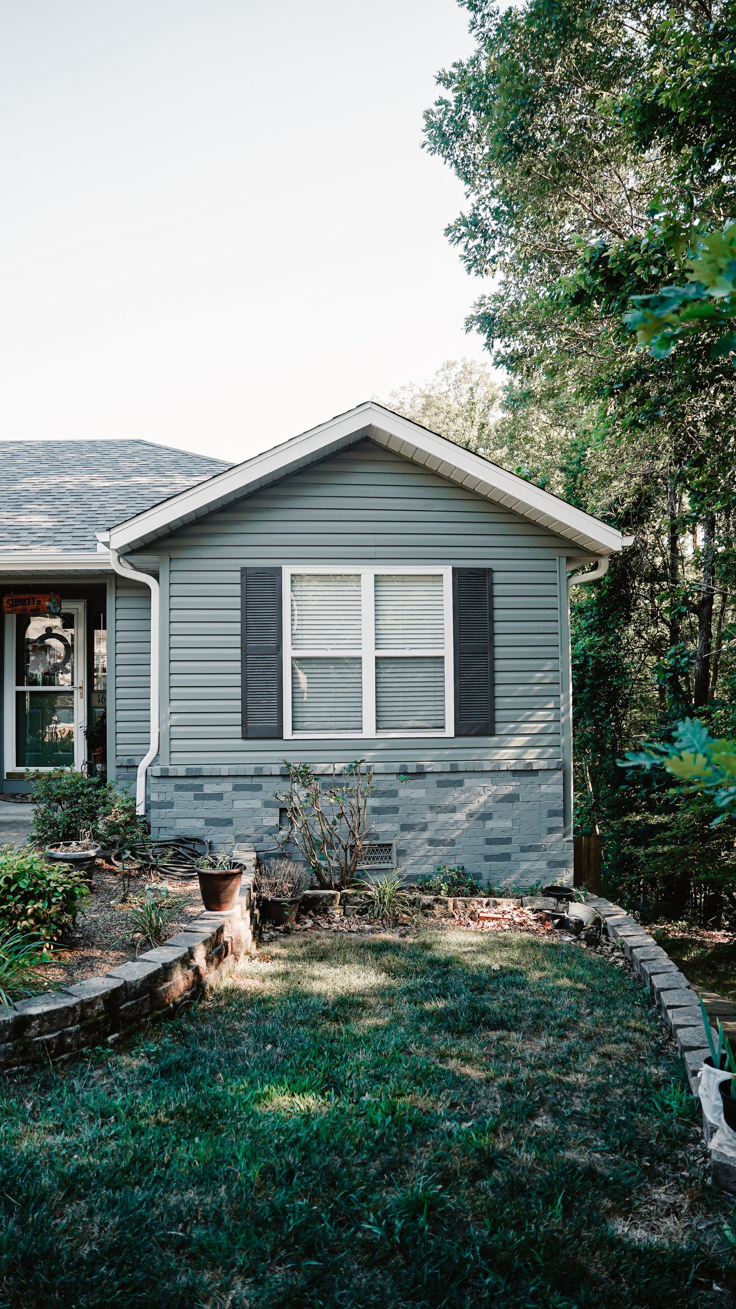 Green house with window and black shutters