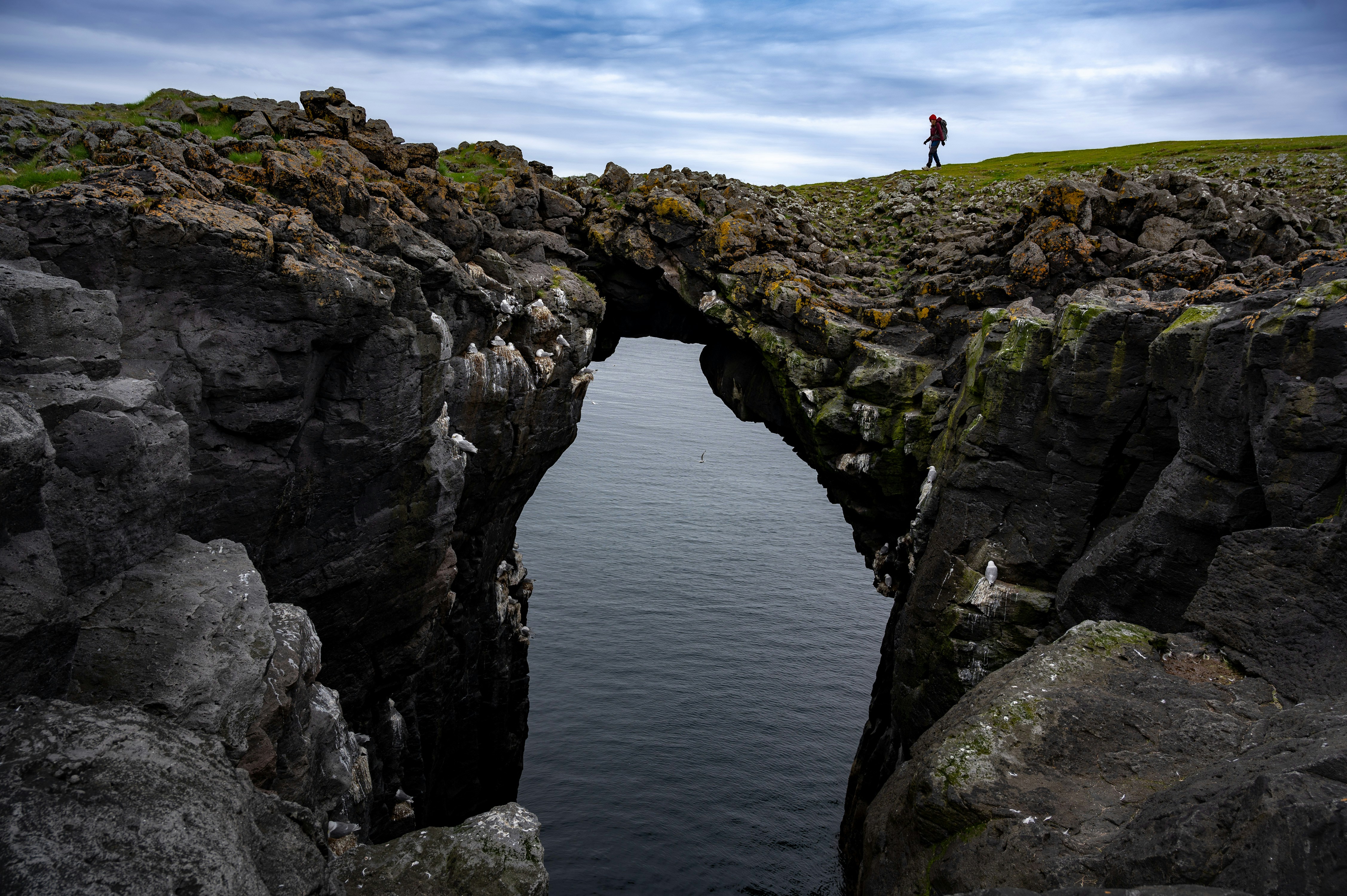 A man standing on the edge of a rock bridge