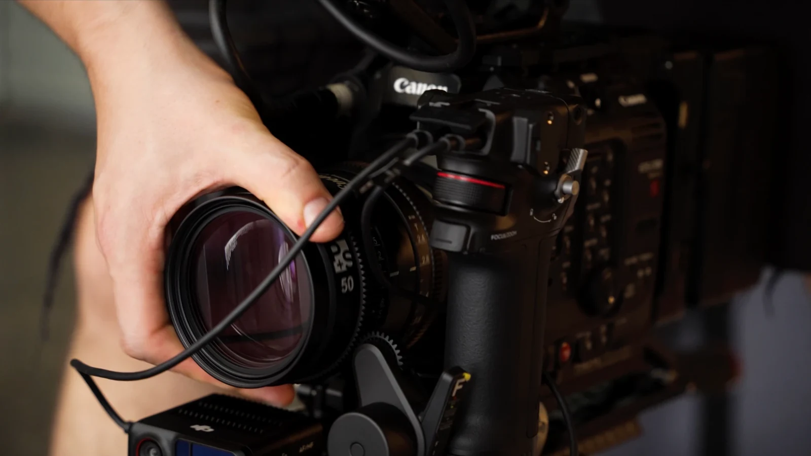 Camera assistant adjusting a cinema lens on the Canon camera