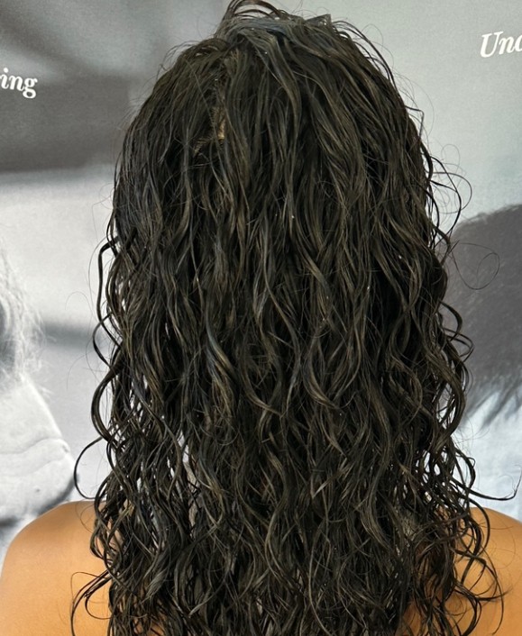 Women’s permanent wave with enhanced texture and rich color, styled for voluminous, natural curls.