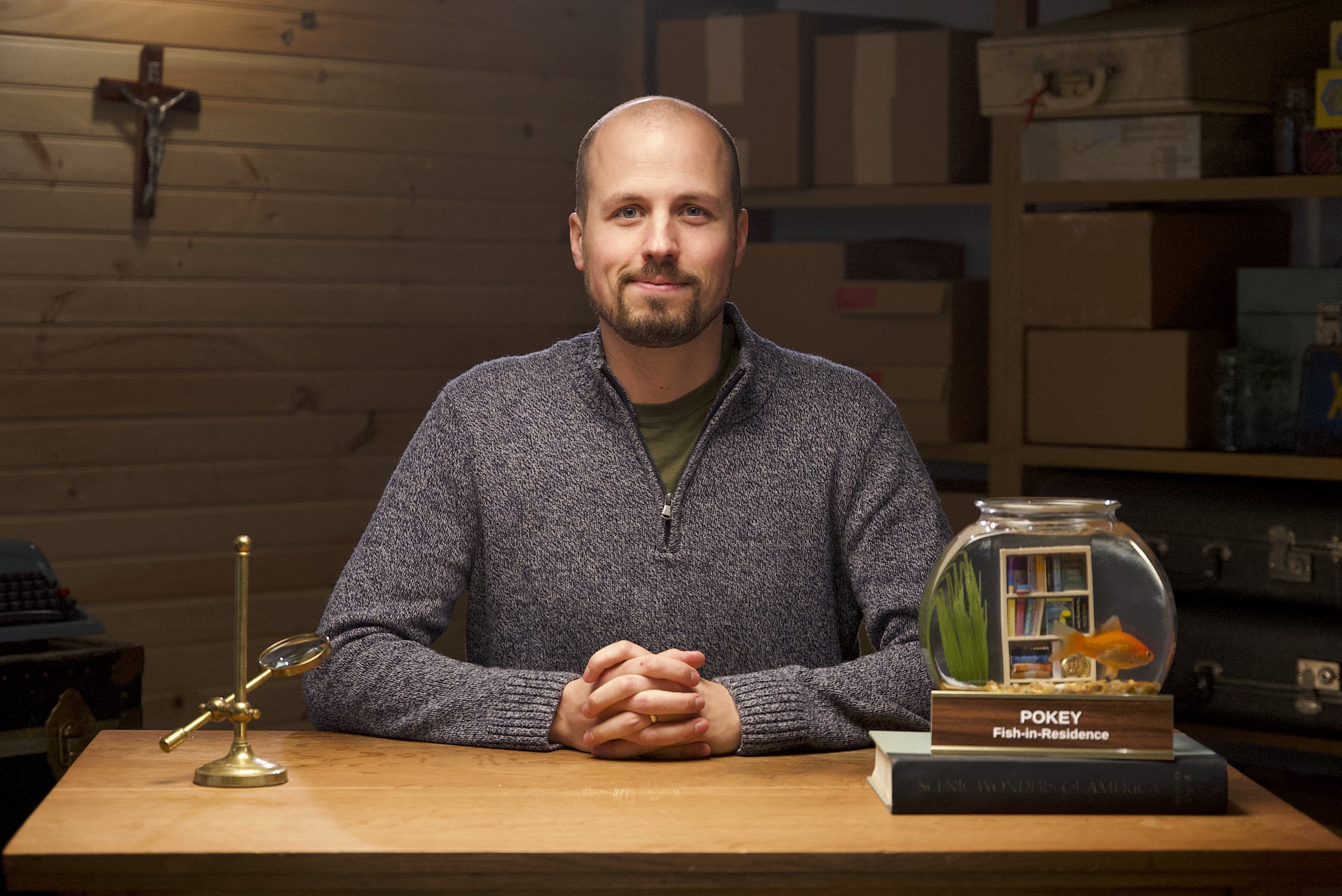 Man in apron stands in rustic kitchen, hands dusted with flour.