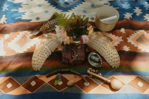 Ceremonial altar with flowers, feathers, and singing bowls