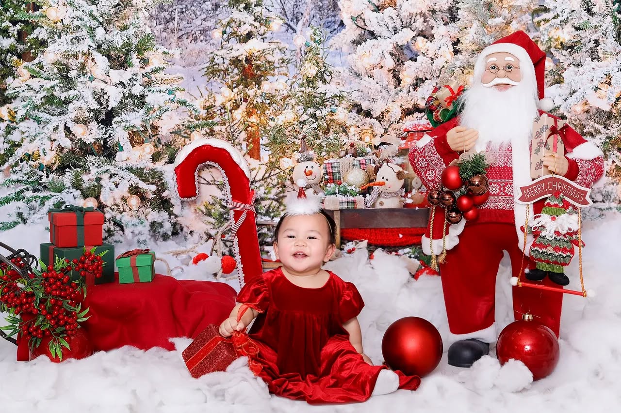 A cute toddler smiling with a Christmas background featured in a festive Christmas photoshoot in Dubai by Mahvin Photography.