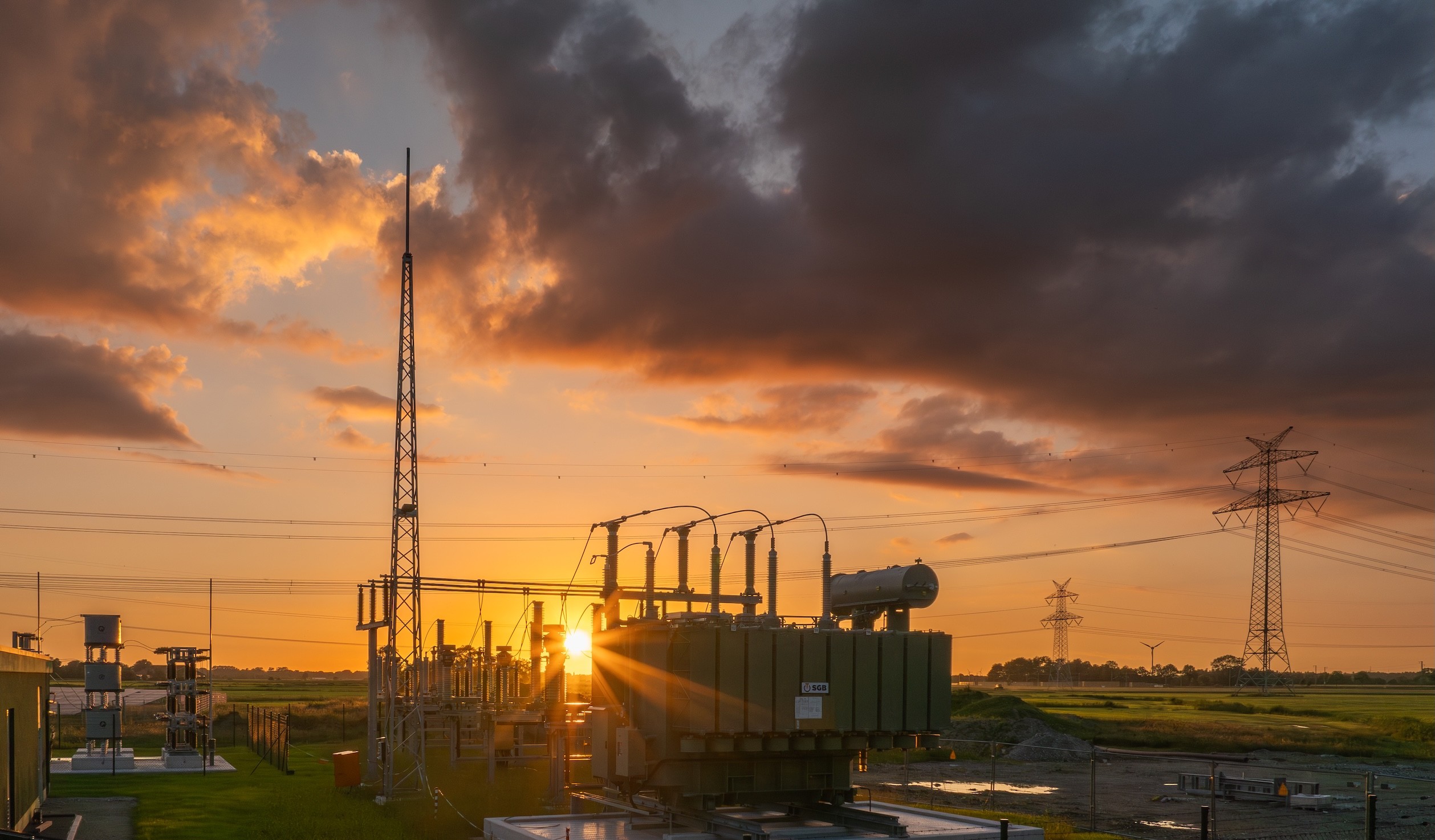 Bilck auf das Umspannwerk im Hybriden Energiepark Sande bei Sonnenuntergang