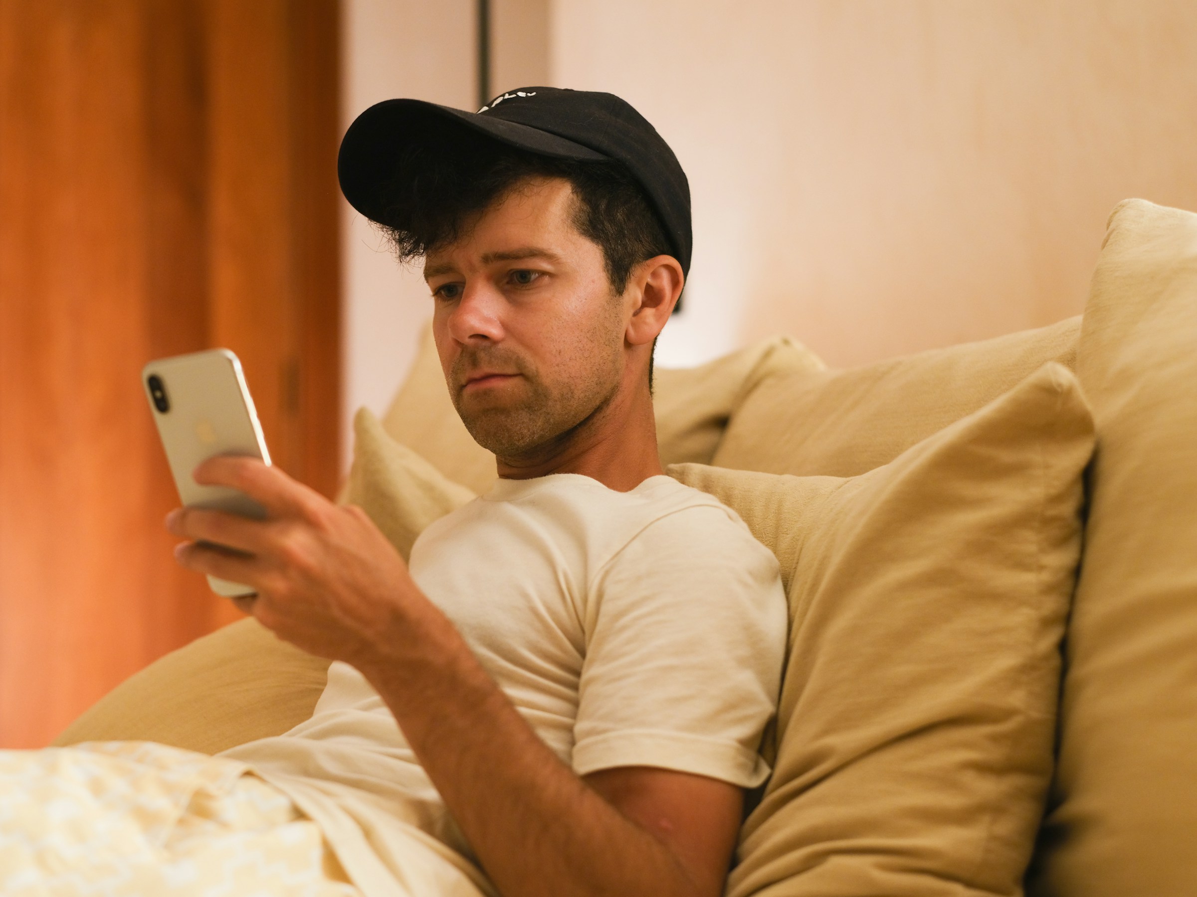 person in bed using phone - Is It Bad to Watch Porn in a Relationship