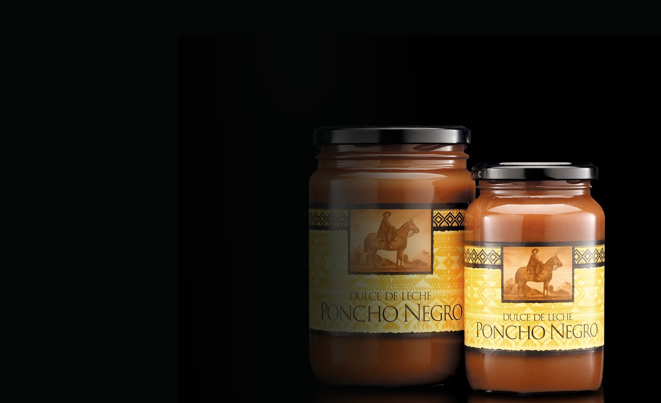 Two jars of "Poncho Negro Dulce de Leche" are displayed against a dark background. The jars have black lids and feature a label with an image of a rider.