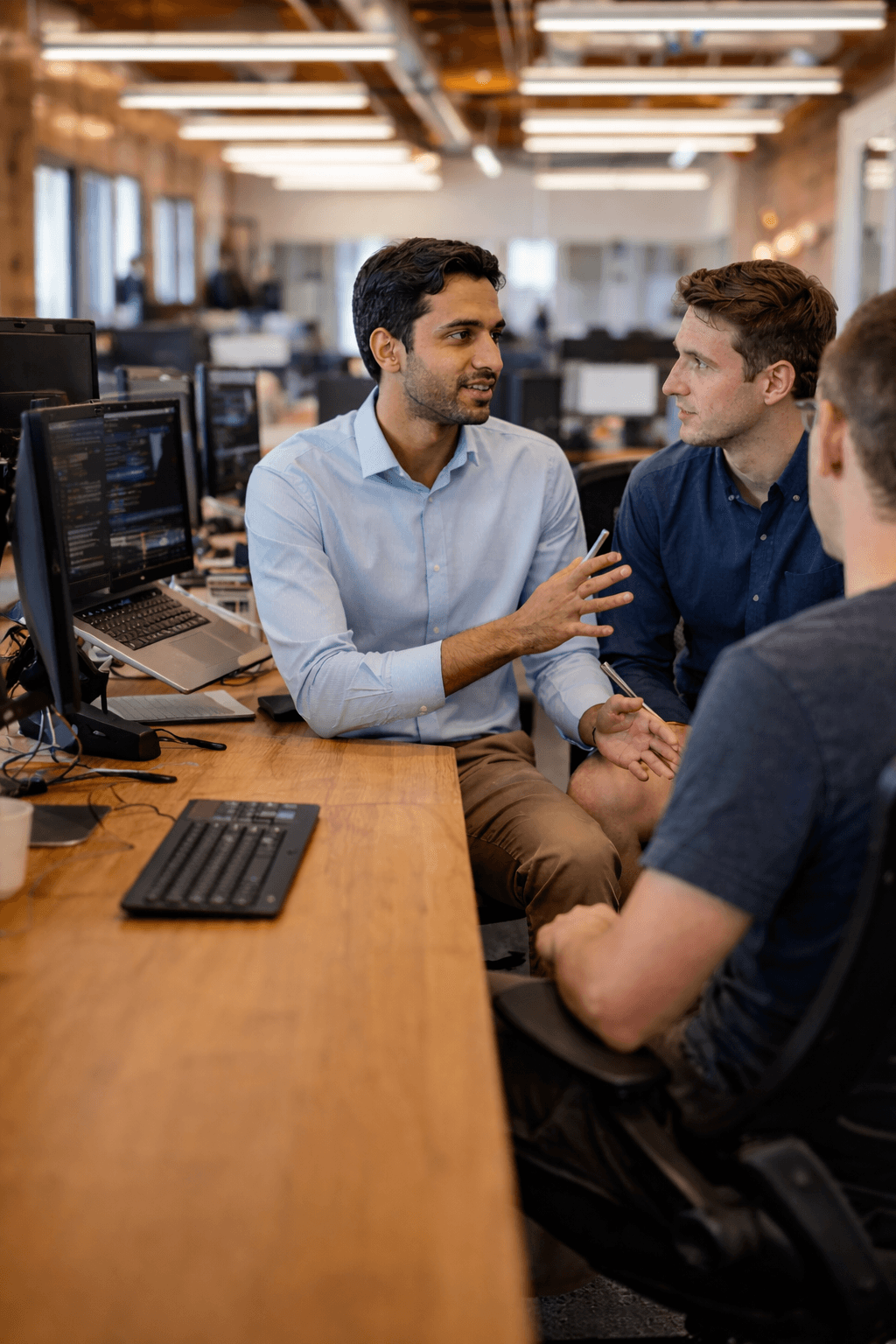 three men sitting on chair beside tables