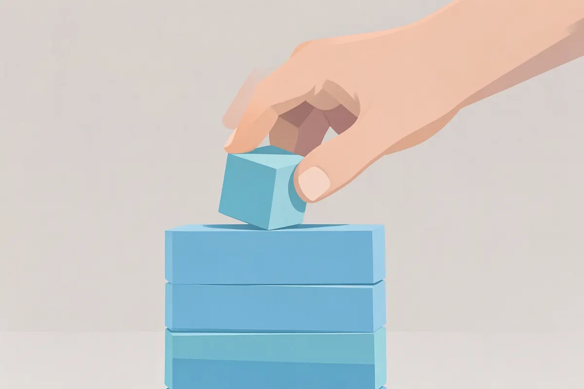 A hand placing a building block onto a stack.