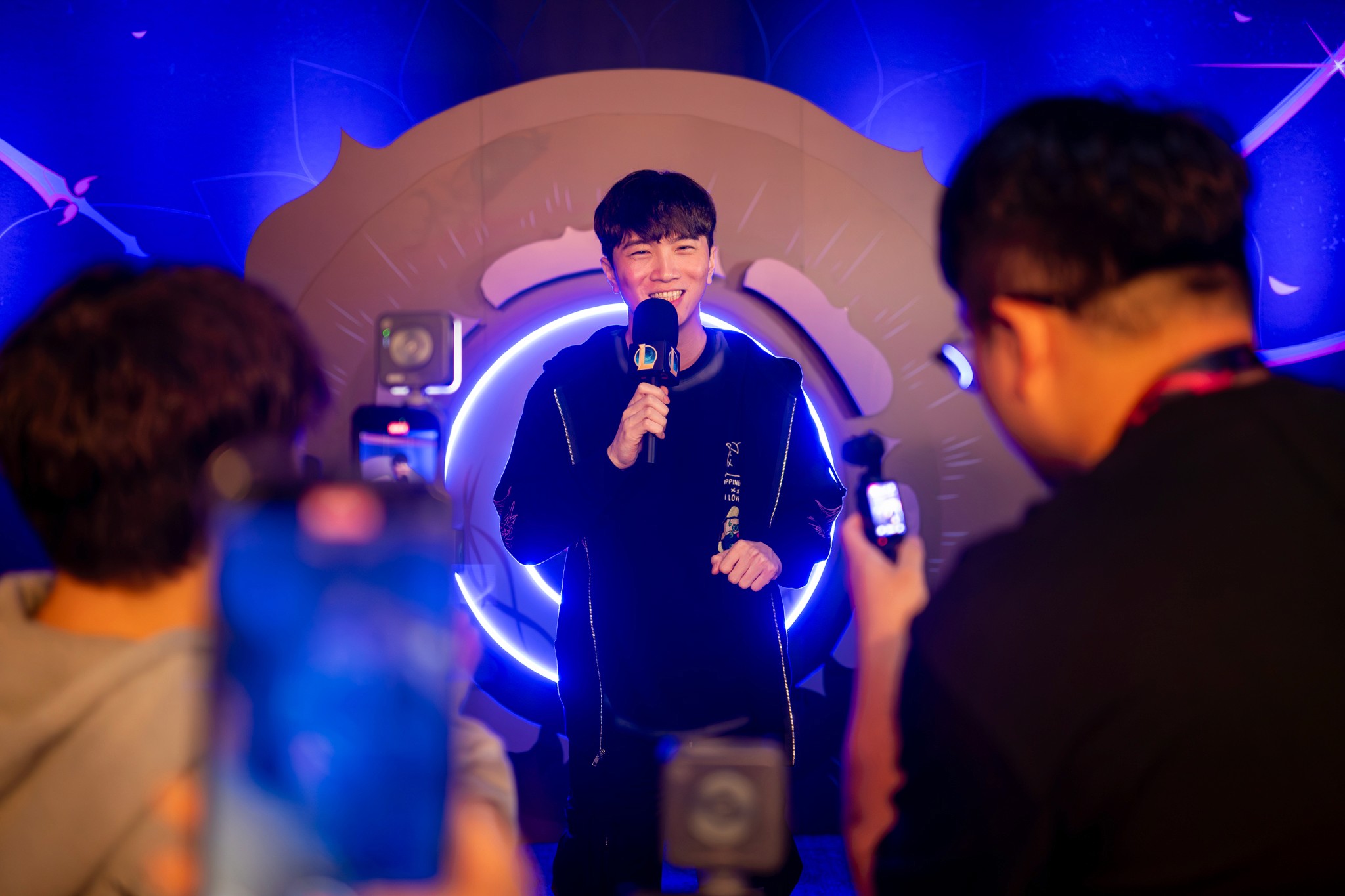 Two attendees networking in a vividly lit blue and purple event space.