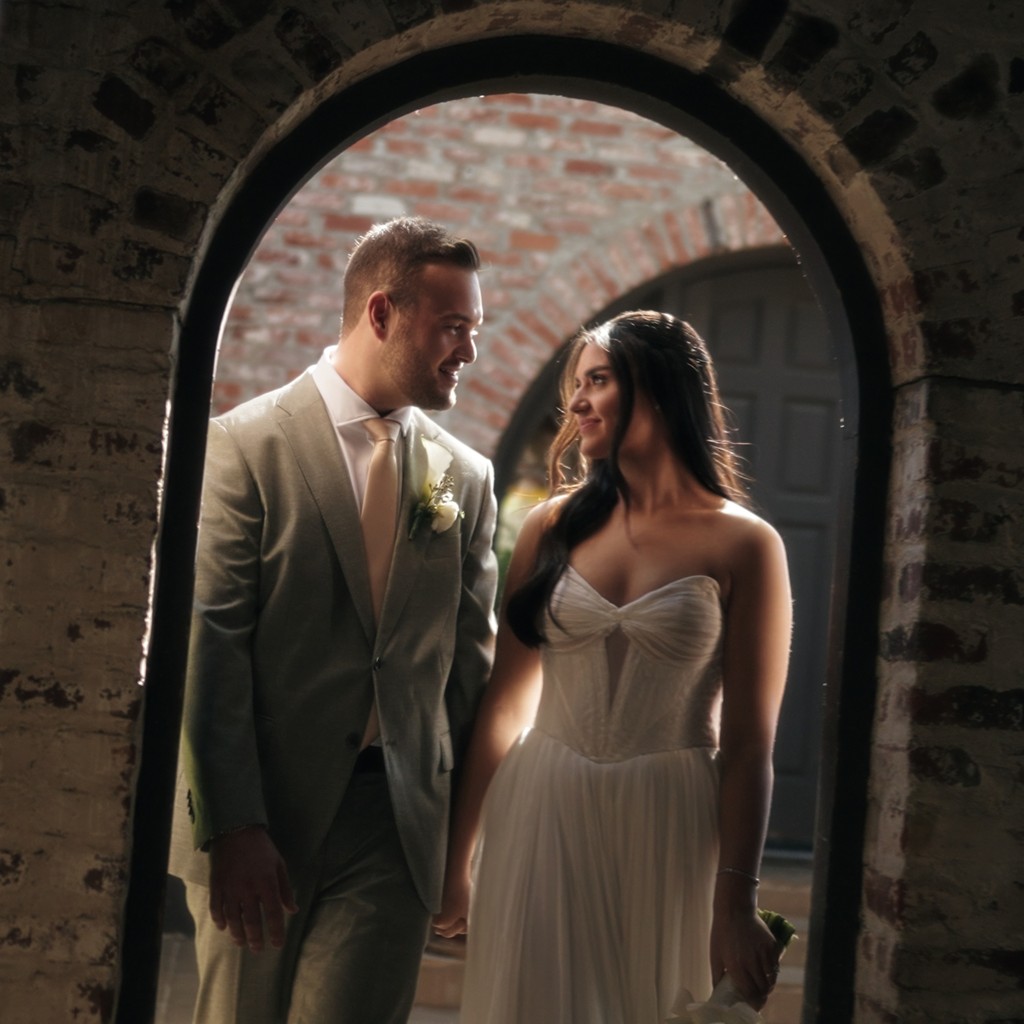 couple standing on wooden dock by the sea during daytime