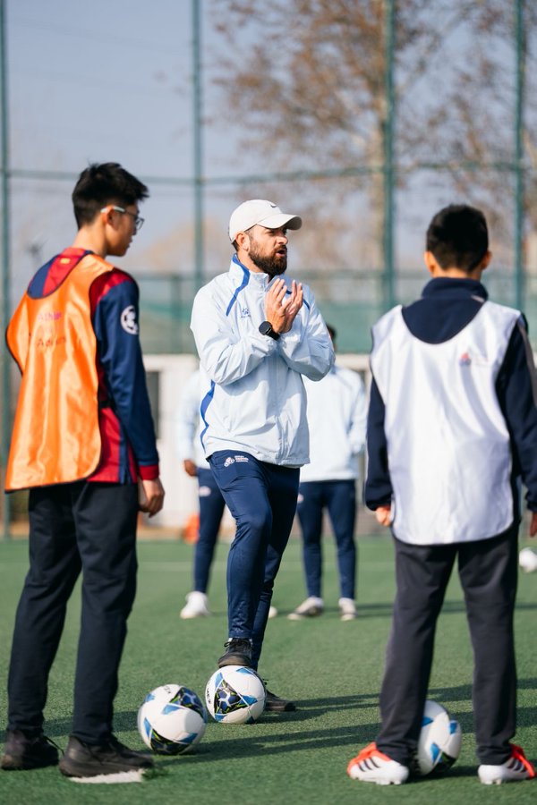 Coach demonstrating ball control to the group