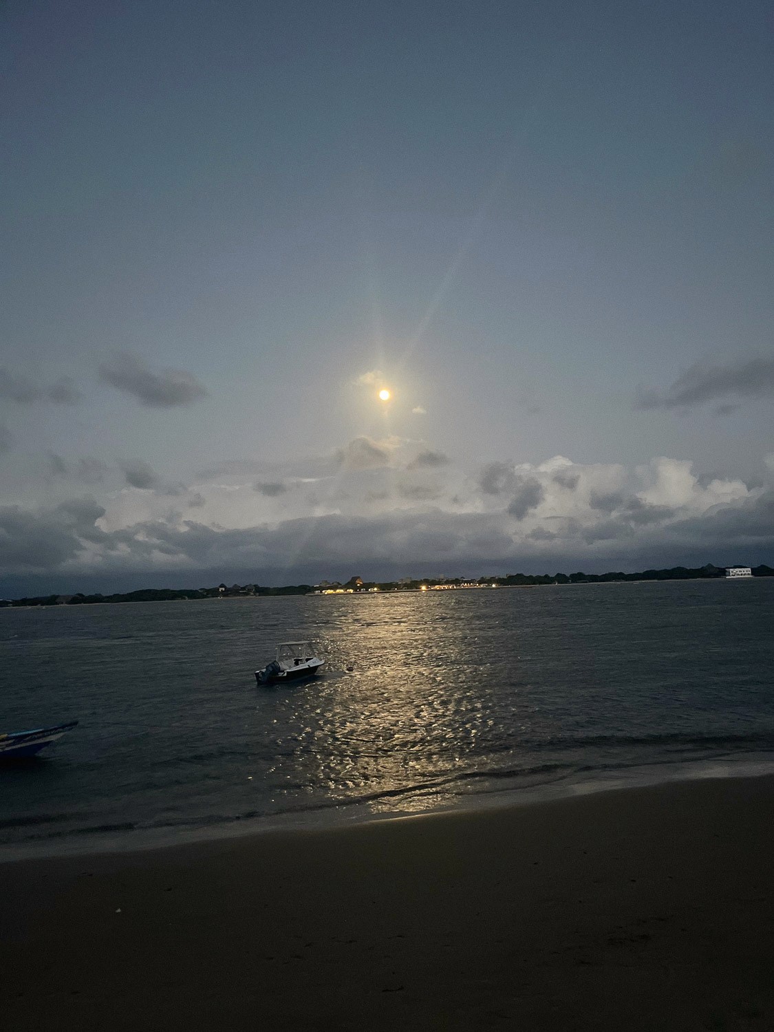 View of the channel from the beach with moon.