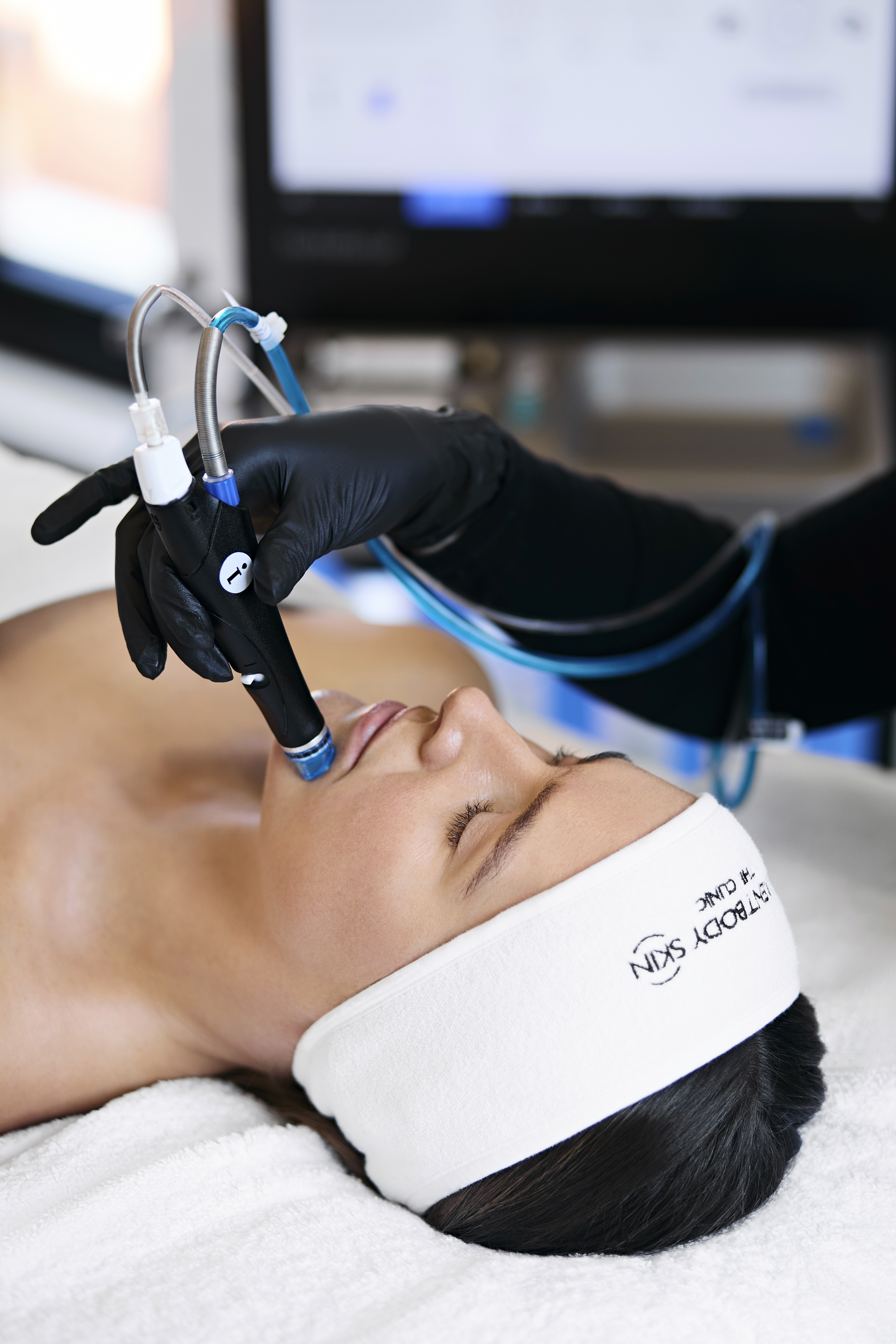 Woman receiving HydraFacial deep-cleansing treatment with professional hydrating device on facial skin