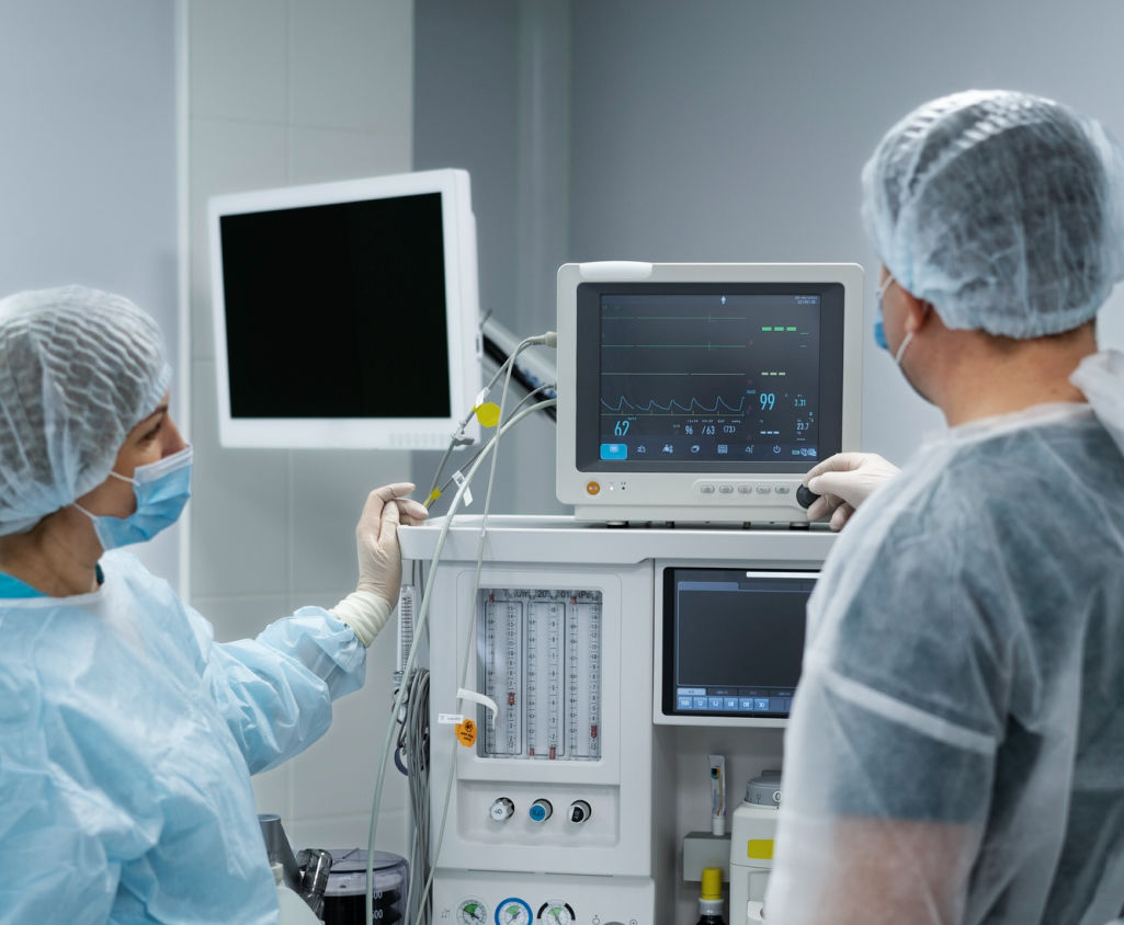 Two individuals in scrub suits collaborating on a computer.