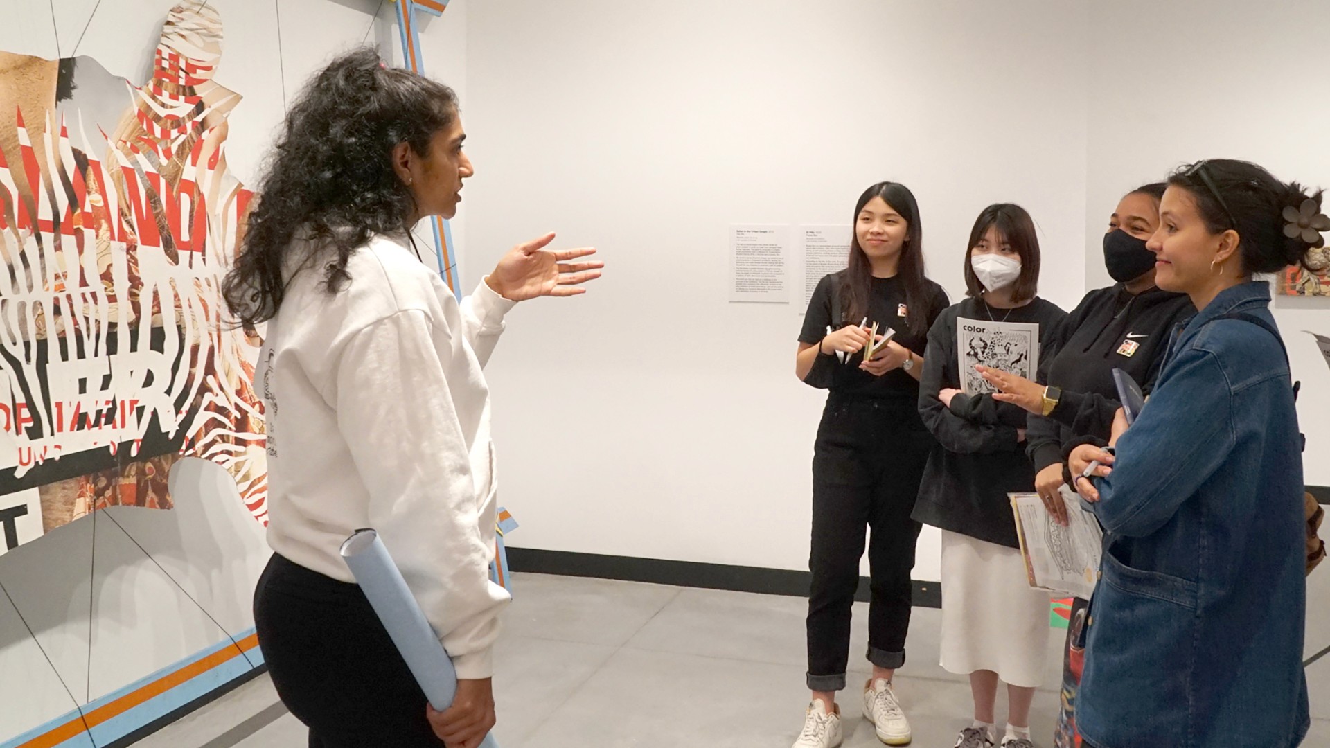 Maya Varadaraj giving a tour of Poster House museum to students