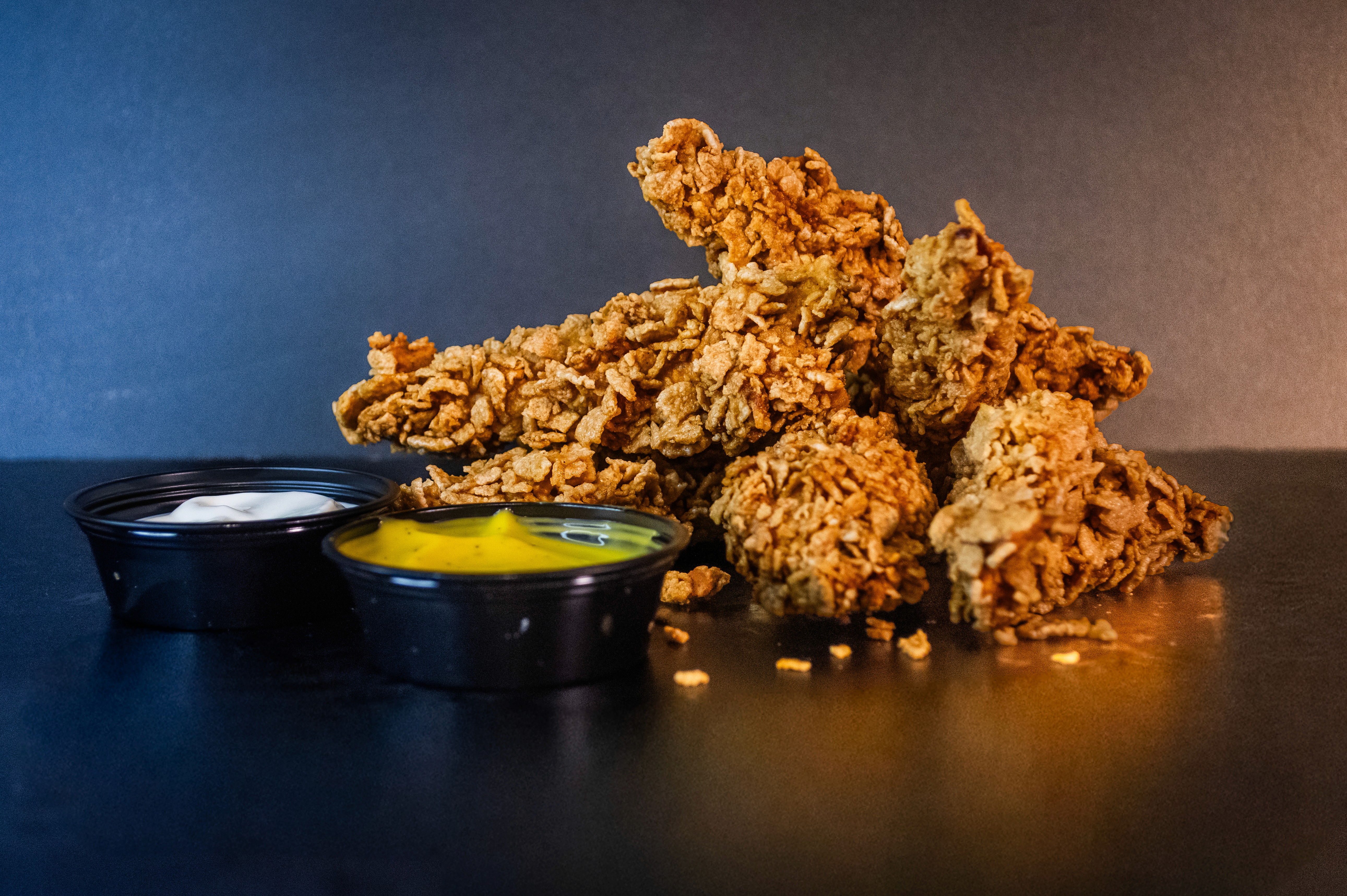 Porción de 6 tiras de pechuga rebozadas acompañadas por dos dips de salsas a elección.