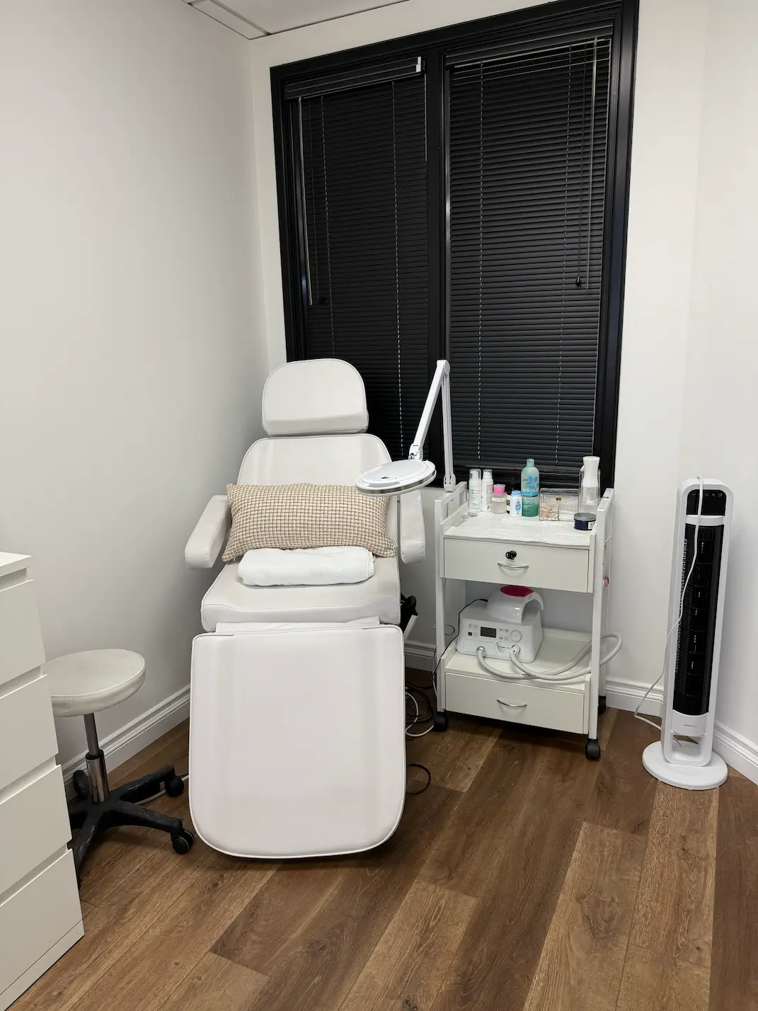 Anti-fatigue mat lying by manicure chair on hardwood floor