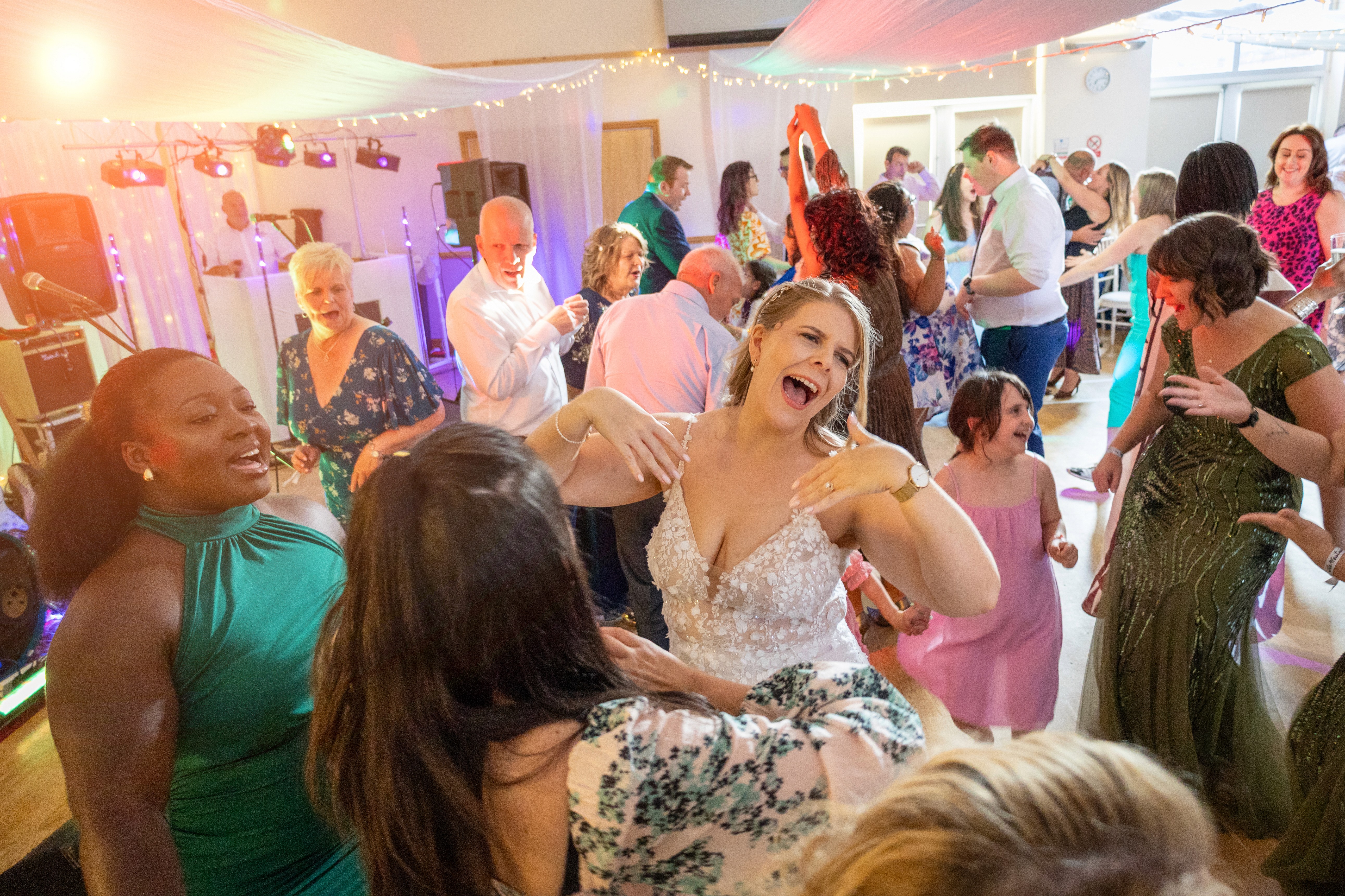 Becs dancing with guests on a lively wedding dancefloor during the evening reception