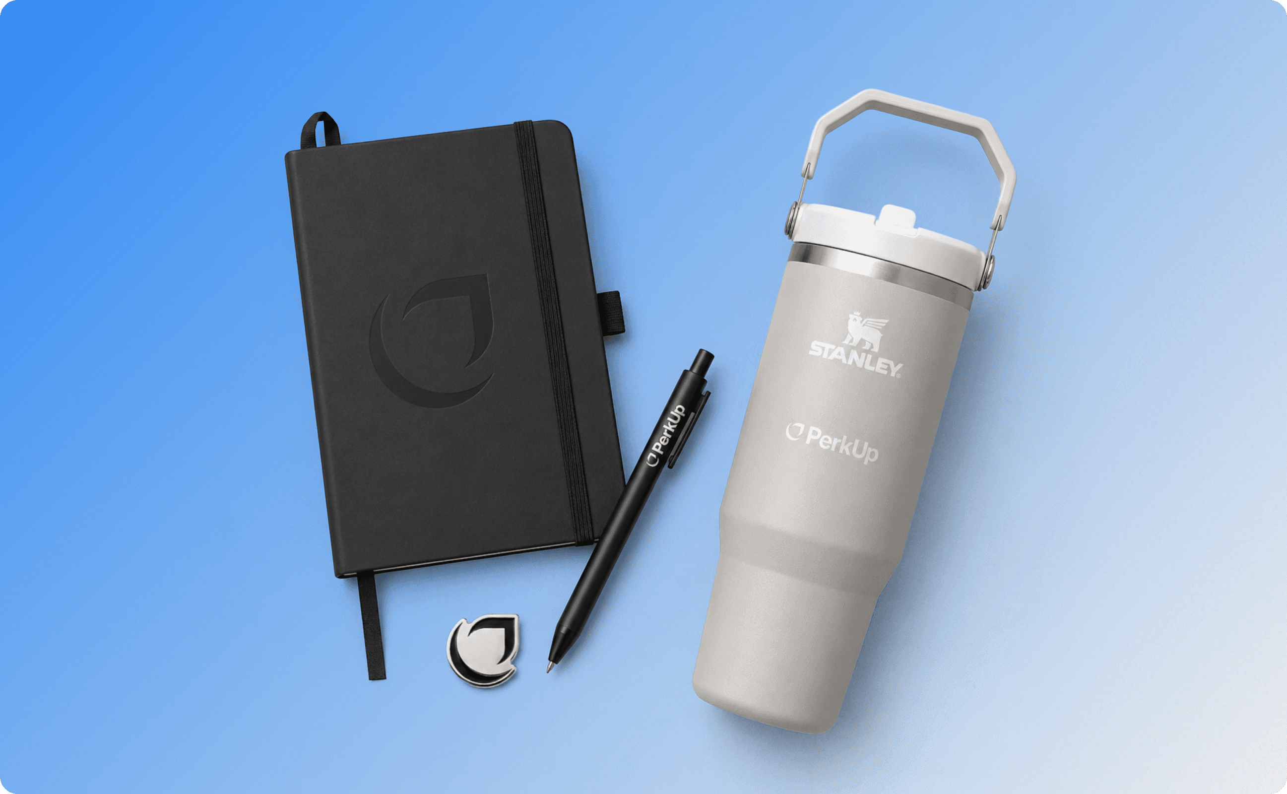 A notebook, a metal pin, a pen, and a Stanley tumbler.