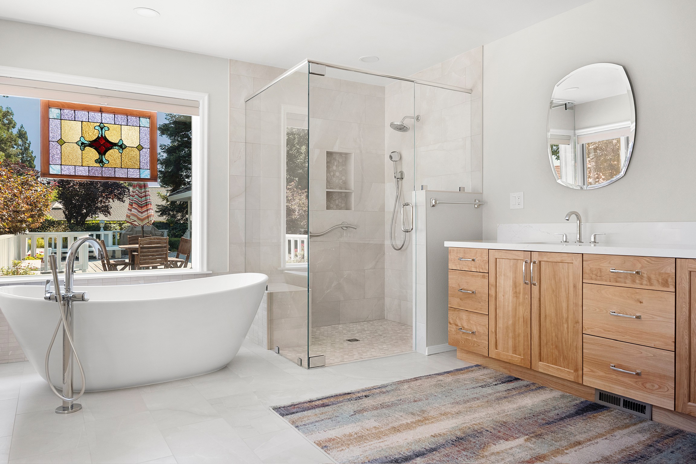 “Bright bathroom remodel with freestanding tub, glass shower, and custom wood vanity”