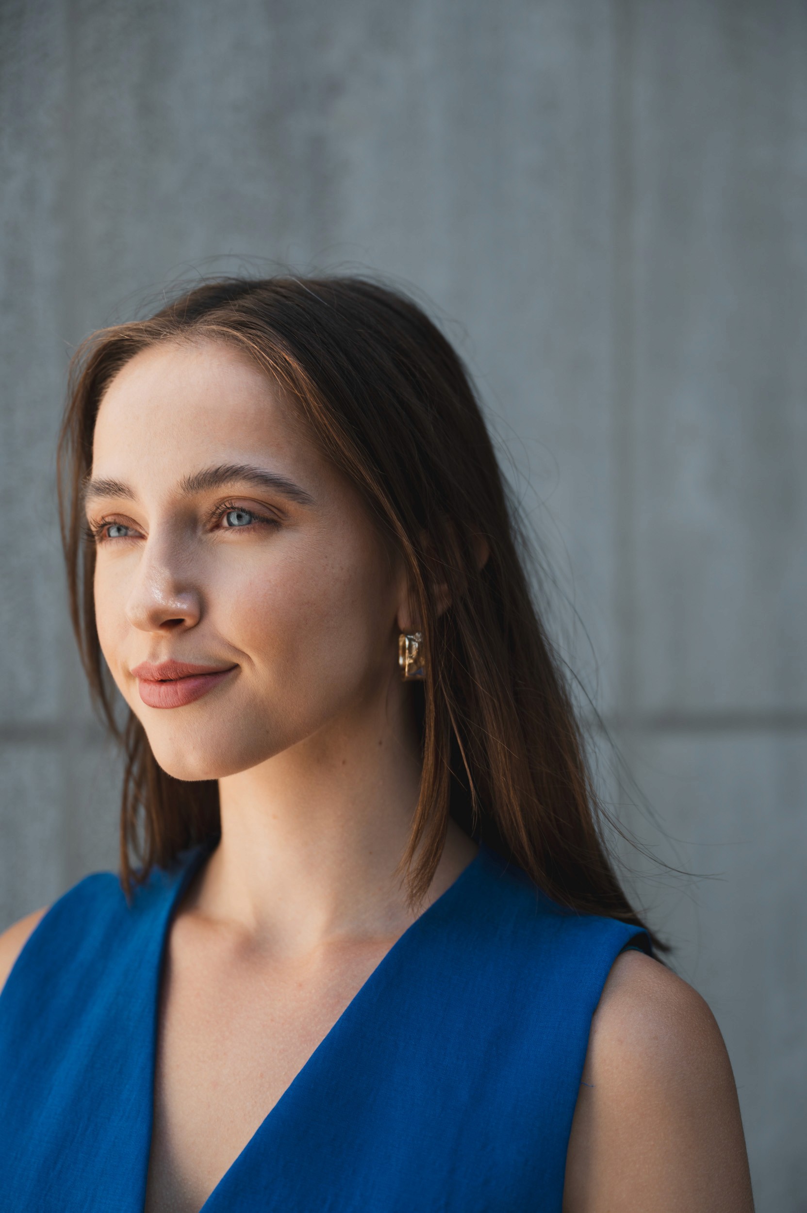 Woman in bathrobe holding champagne glass on bed.